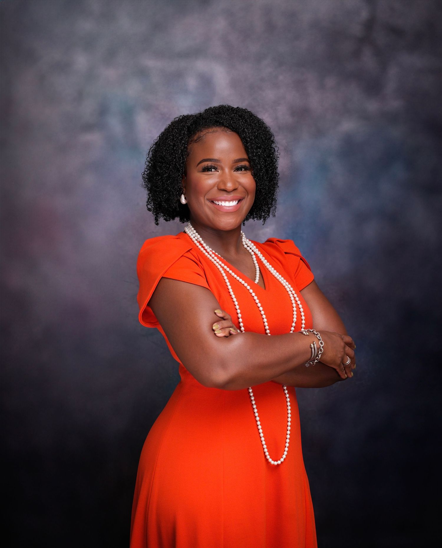 Portrait series featuring person in bright orange dress with pearl necklace against dark background.