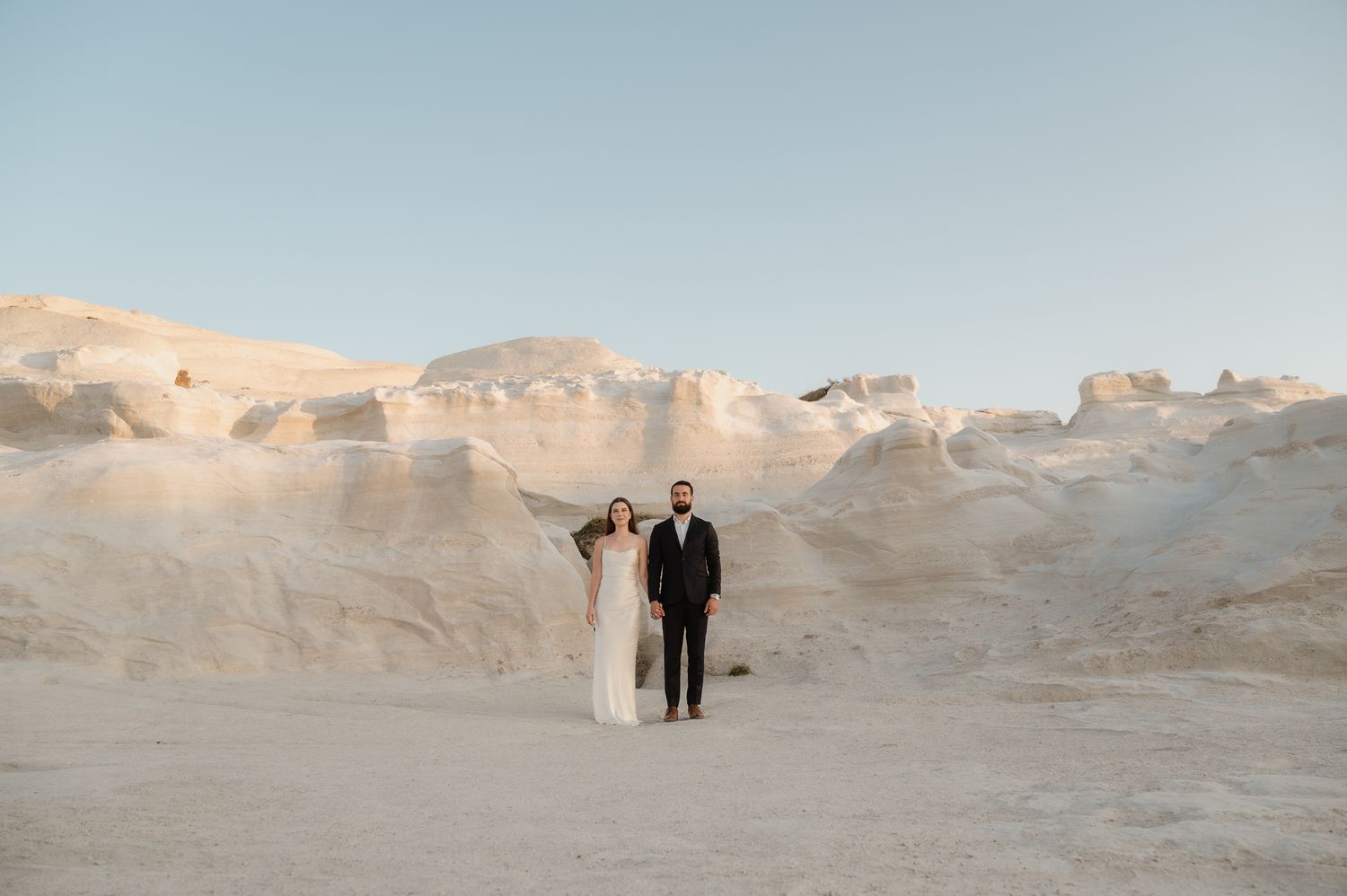 A cinematic photo of a couple kissing at their elopement at Sarakiniko beach, Milos Greece