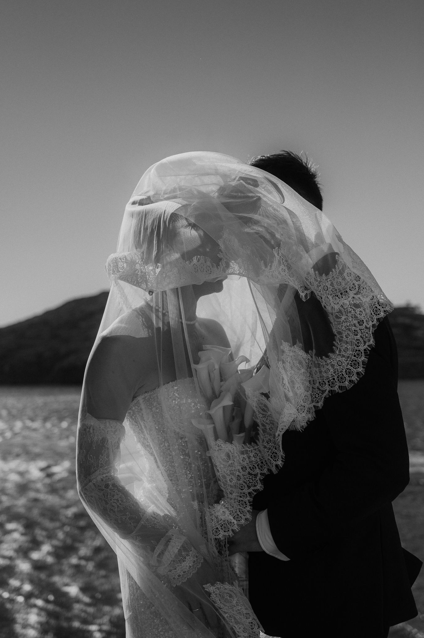 bride and groom kiss behind veil cinematic wedding photography in Ios Paros Tinos Sifnos Mykonos Greece