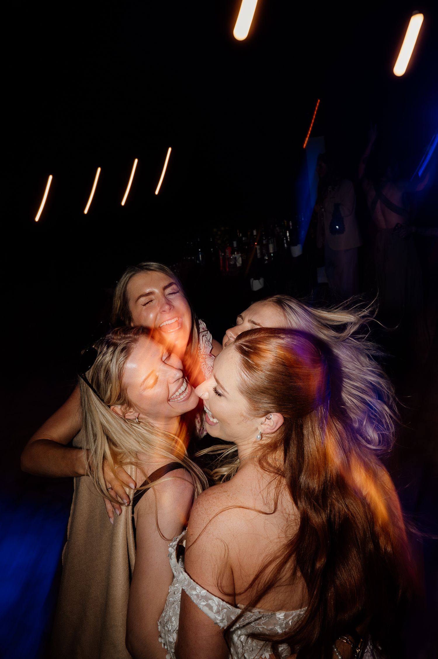 A modern candid photo of a bride with her friends dancing at the wedding party in Corfu, Greece
