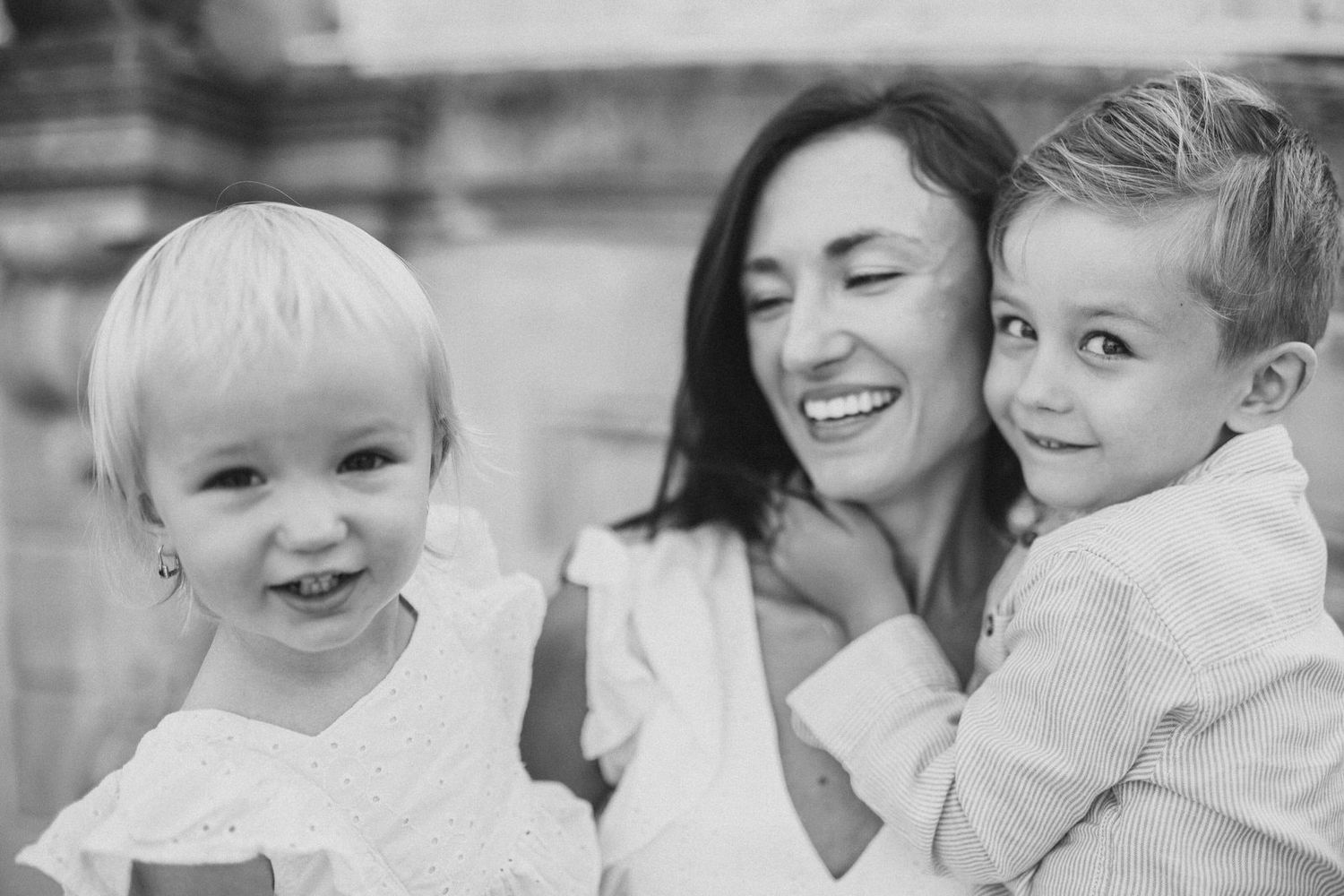 Black and white candid portrait showing joyful laughter and connection between family members.