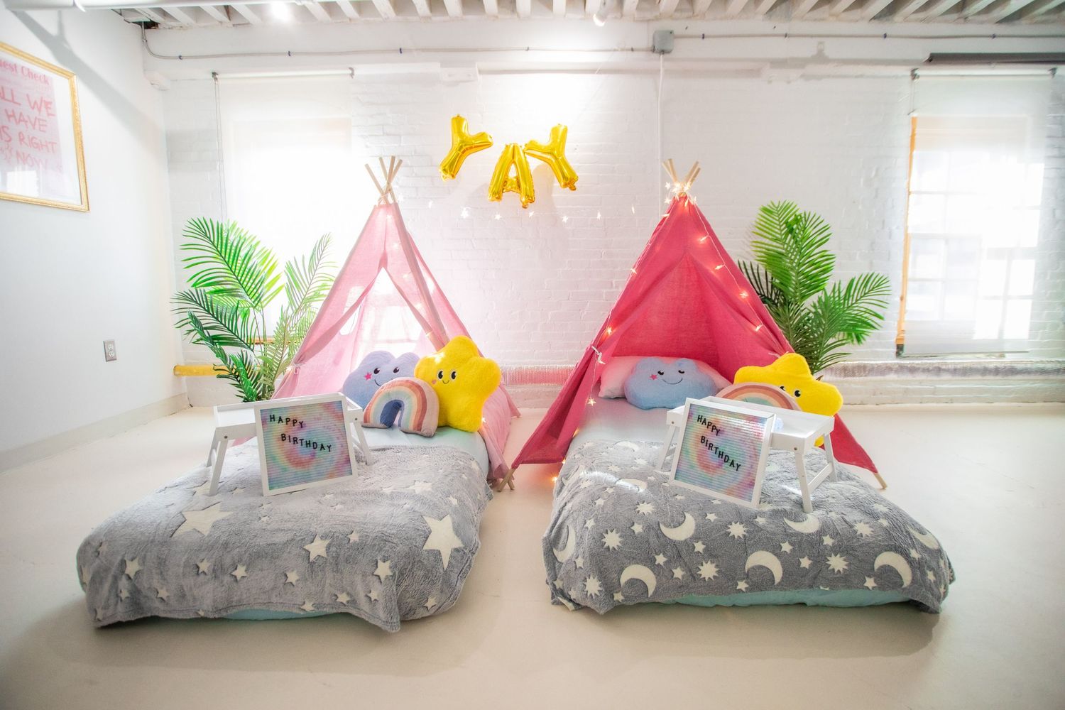 Bright kids sleepover setup with two pink teepees, star-print bedding, and rainbow plush toys.