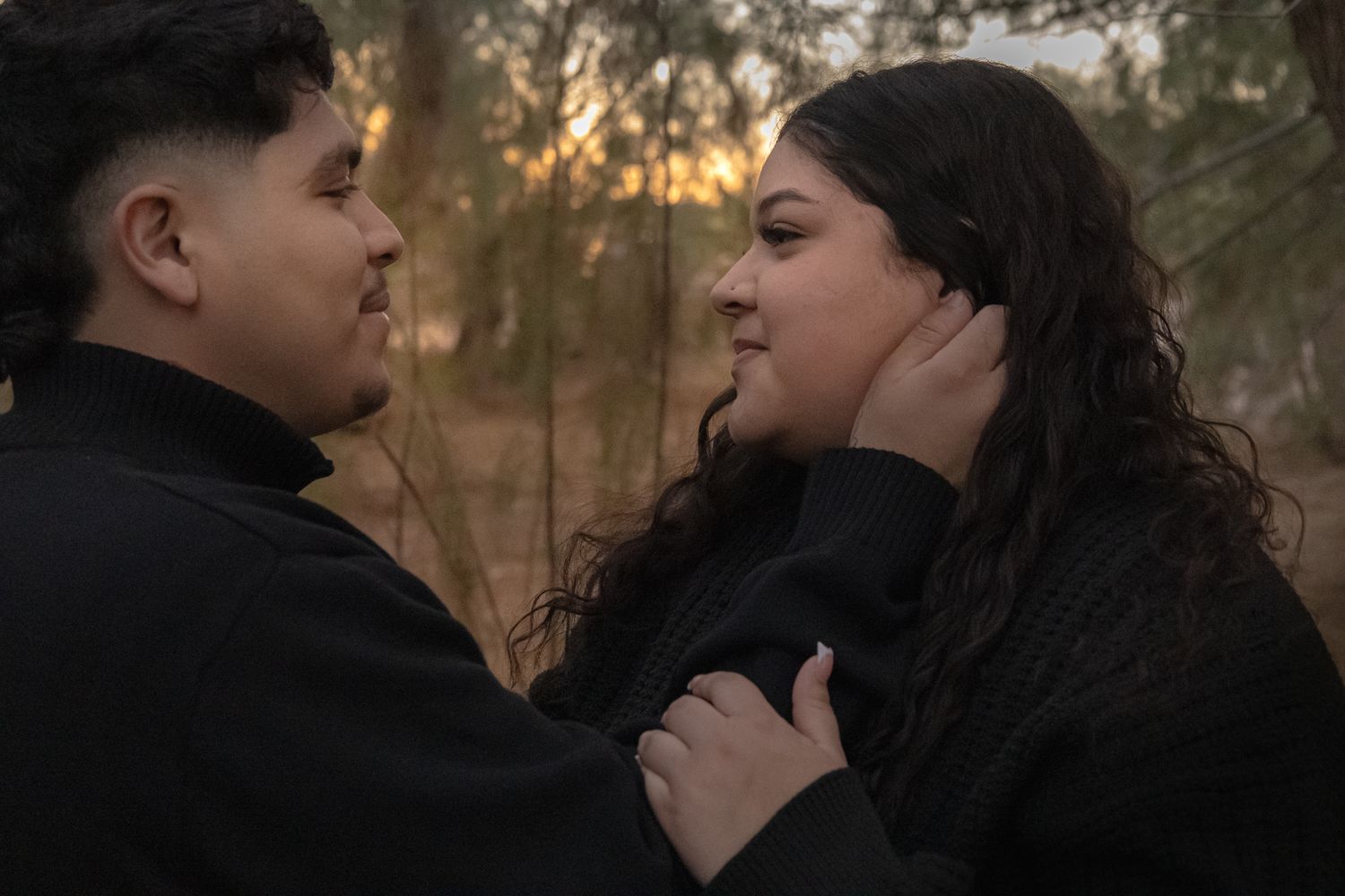 Professional photo, sunset picture over a lake, A man tucking a womans hair behind her ear, lots of giggles, soft colors