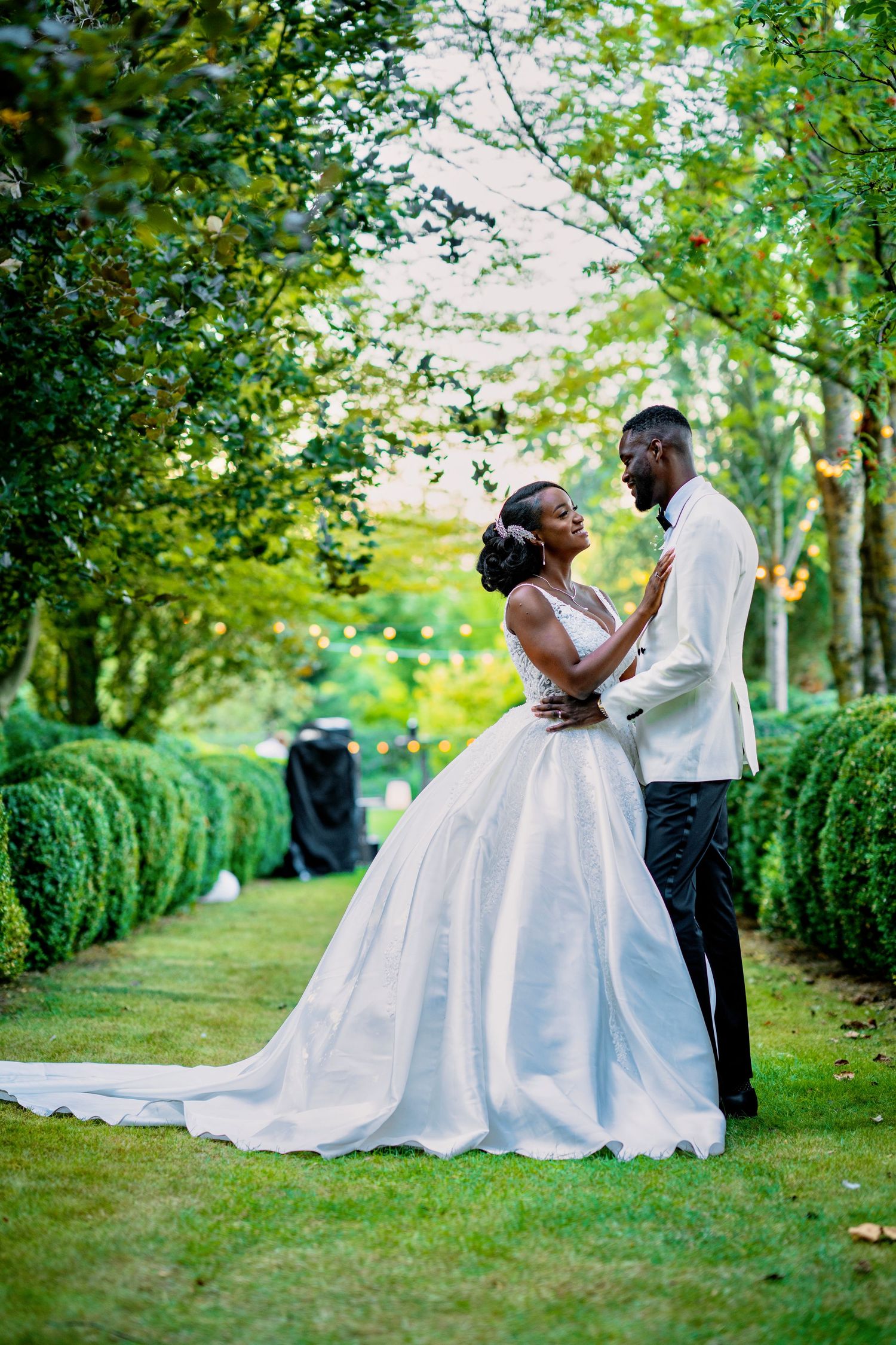 Romantic outdoor wedding photography in a lush garden setting with white wedding gown.