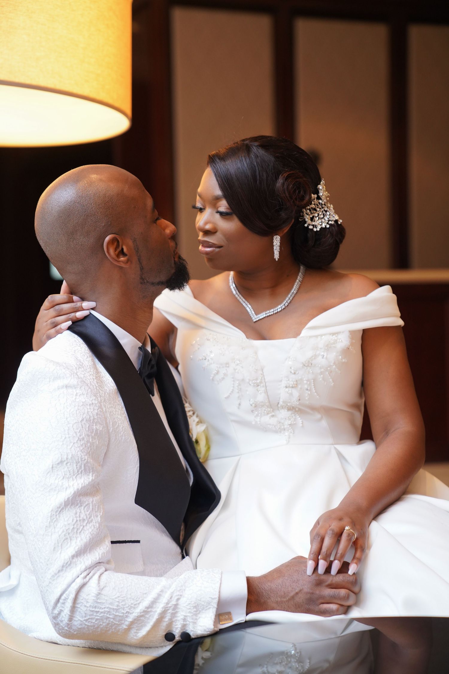 Intimate wedding moment captured in white formal attire with elegant accessories.