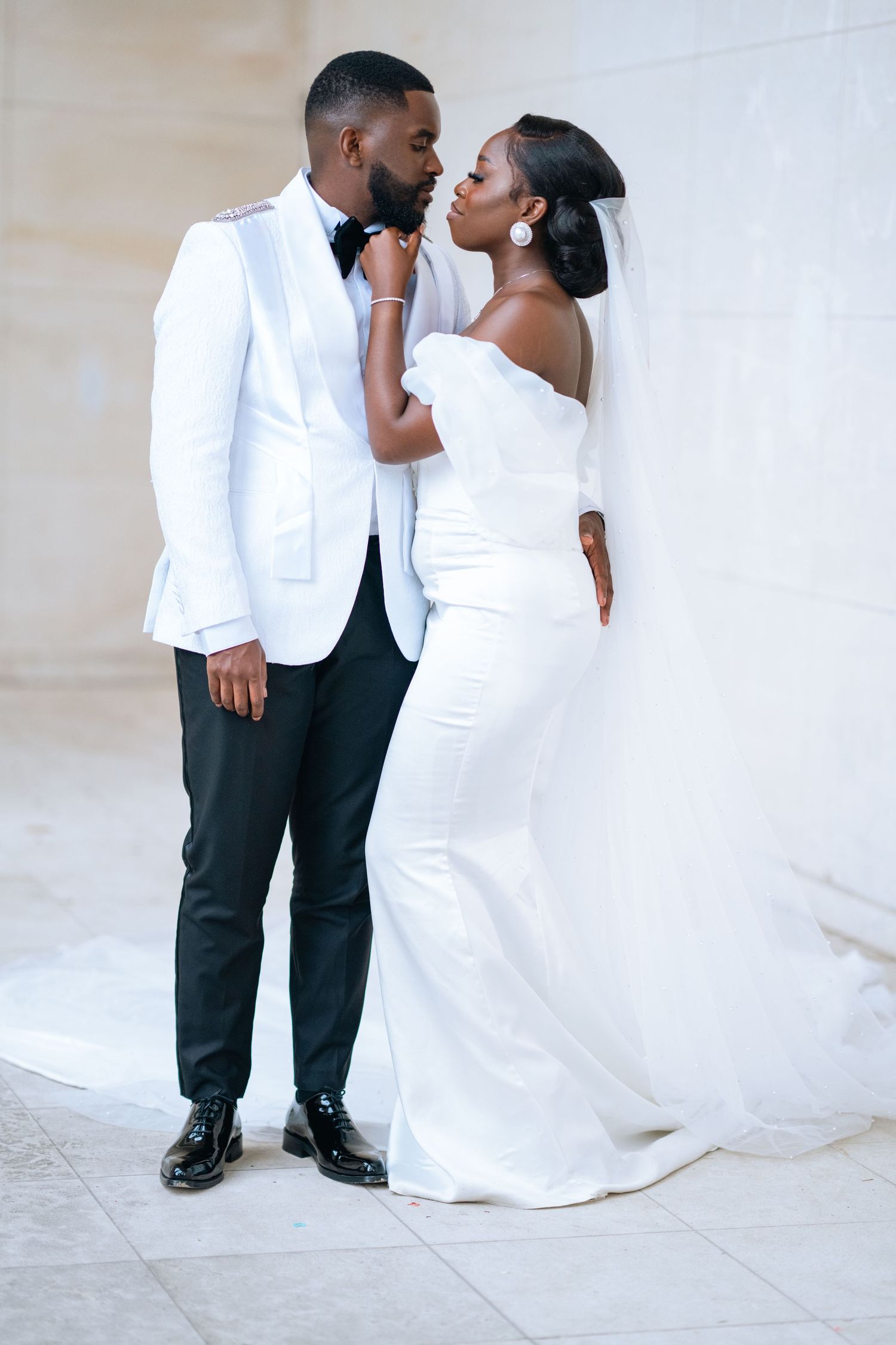 Romantic wedding couple in formal attire share intimate moments in a series of elegant poses against a light background.