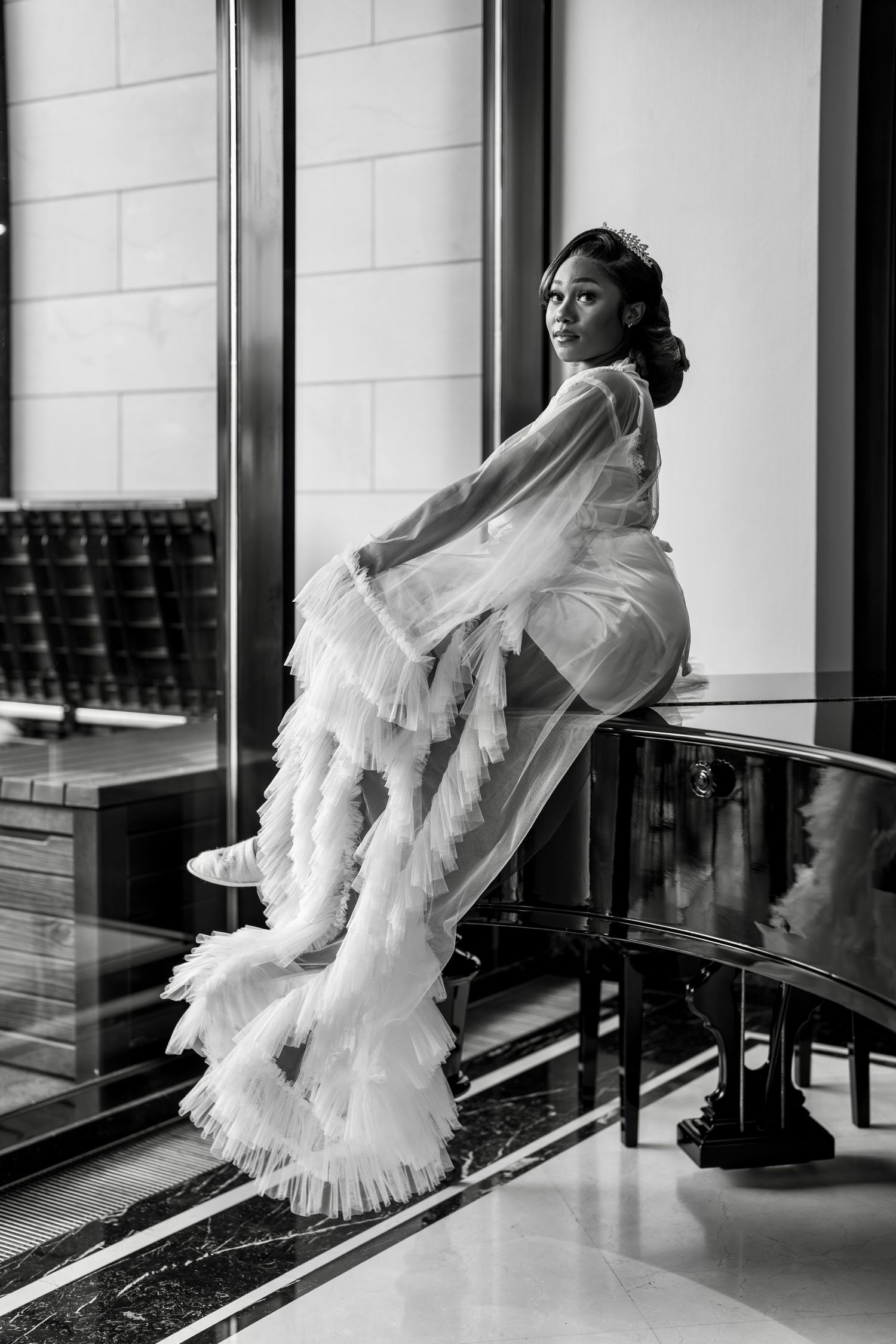 Black and white bridal portraits showing flowing white dress details against modern architecture.