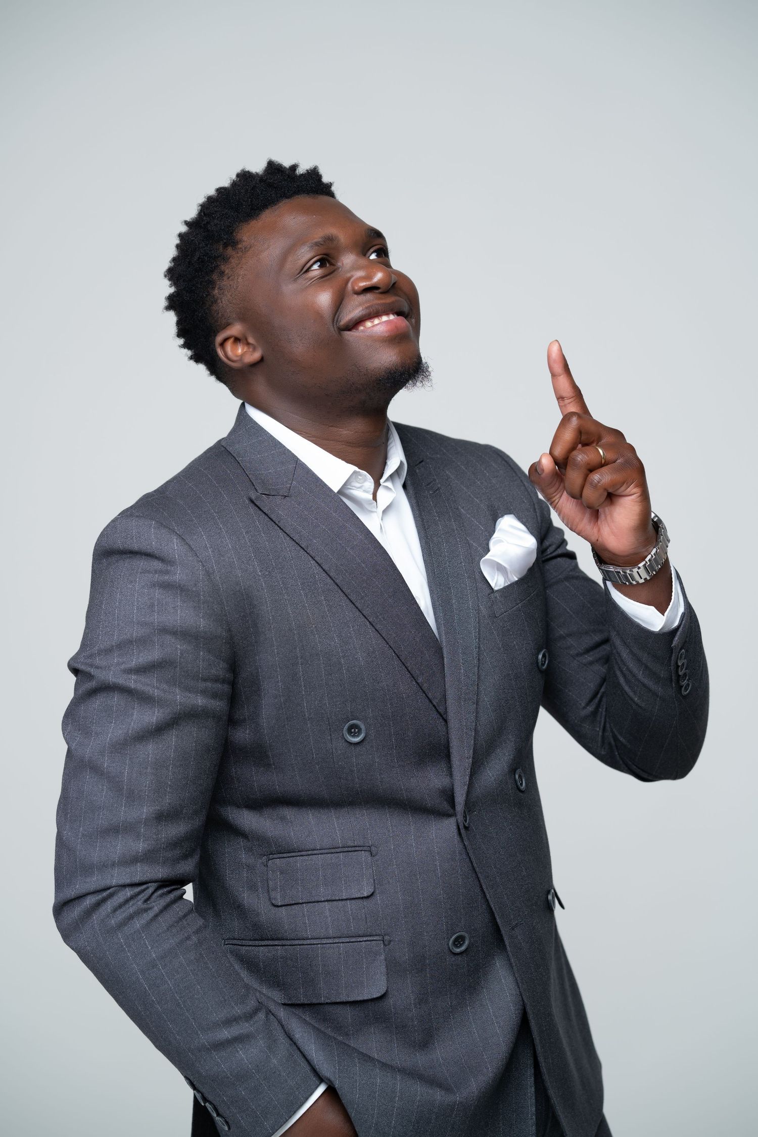 Man in grey suit strikes dynamic poses against white studio background.