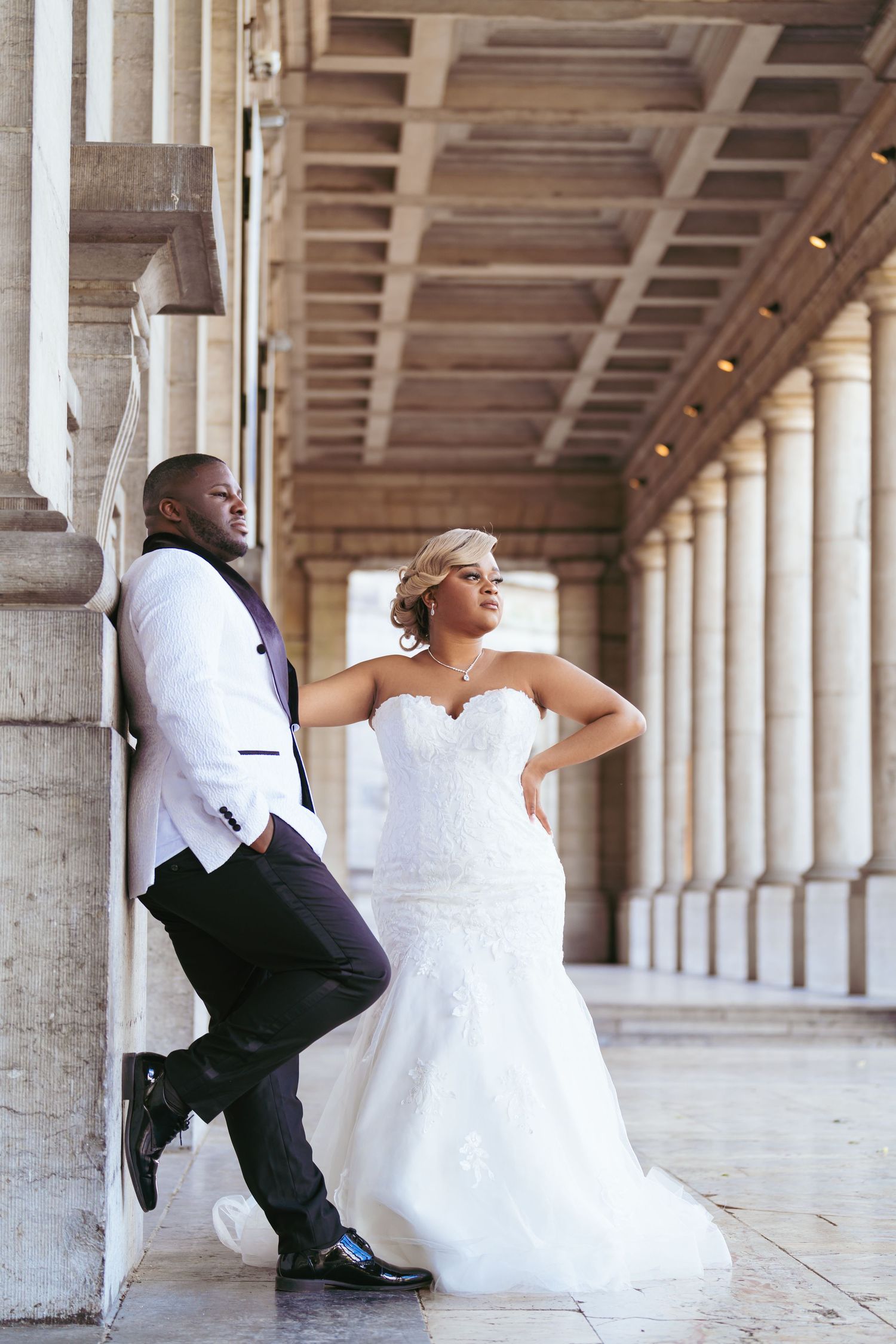 A creative wedding photo series under a colonnade with white pillars and wooden ceiling.
