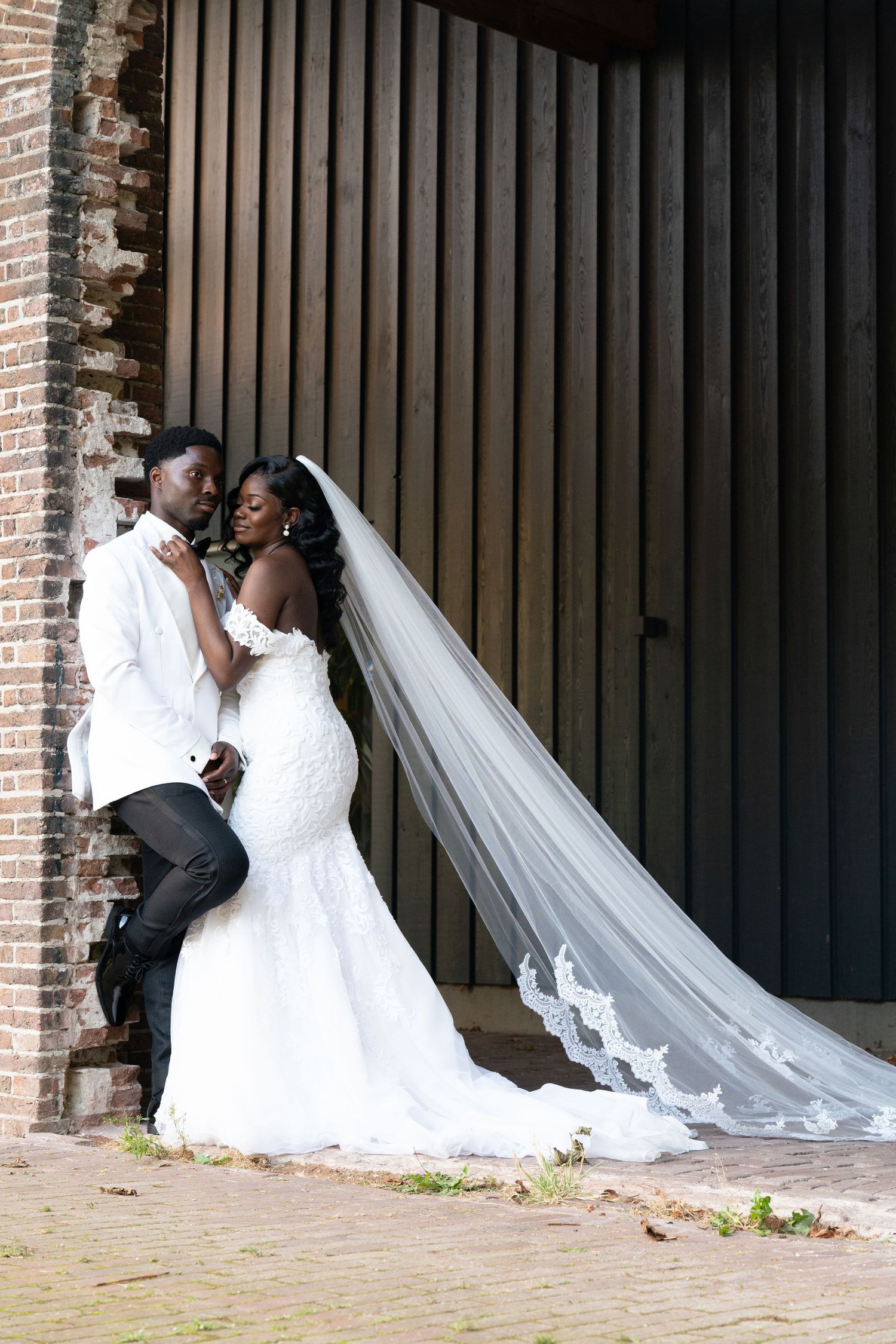 A series of romantic wedding photos showing a couple in white against a dark brick and wood backdrop.