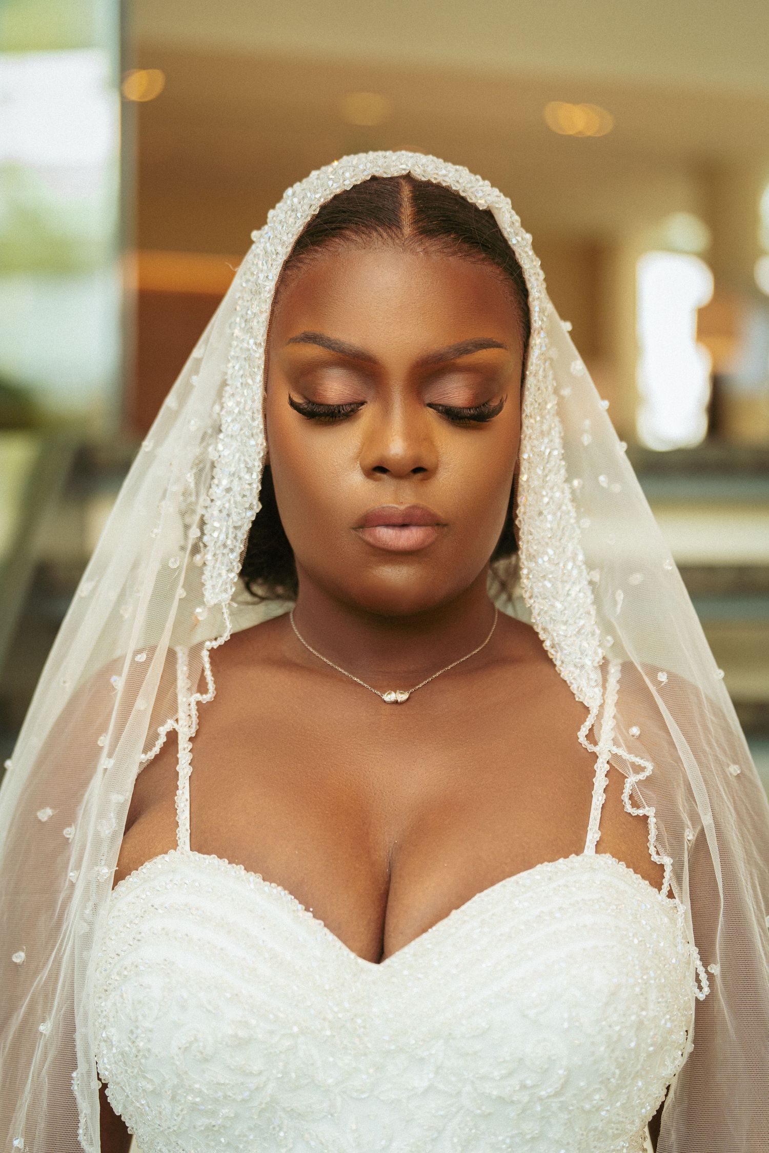 Close-up bridal portrait showcasing delicate lace veil and classic wedding makeup.