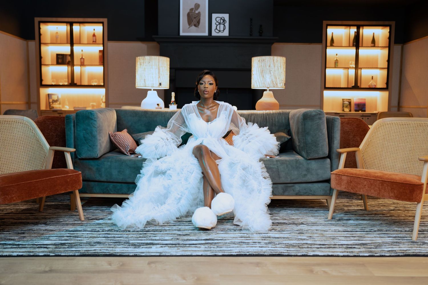 Lifestyle photography session in an elegant living room with teal furniture and warm lighting.