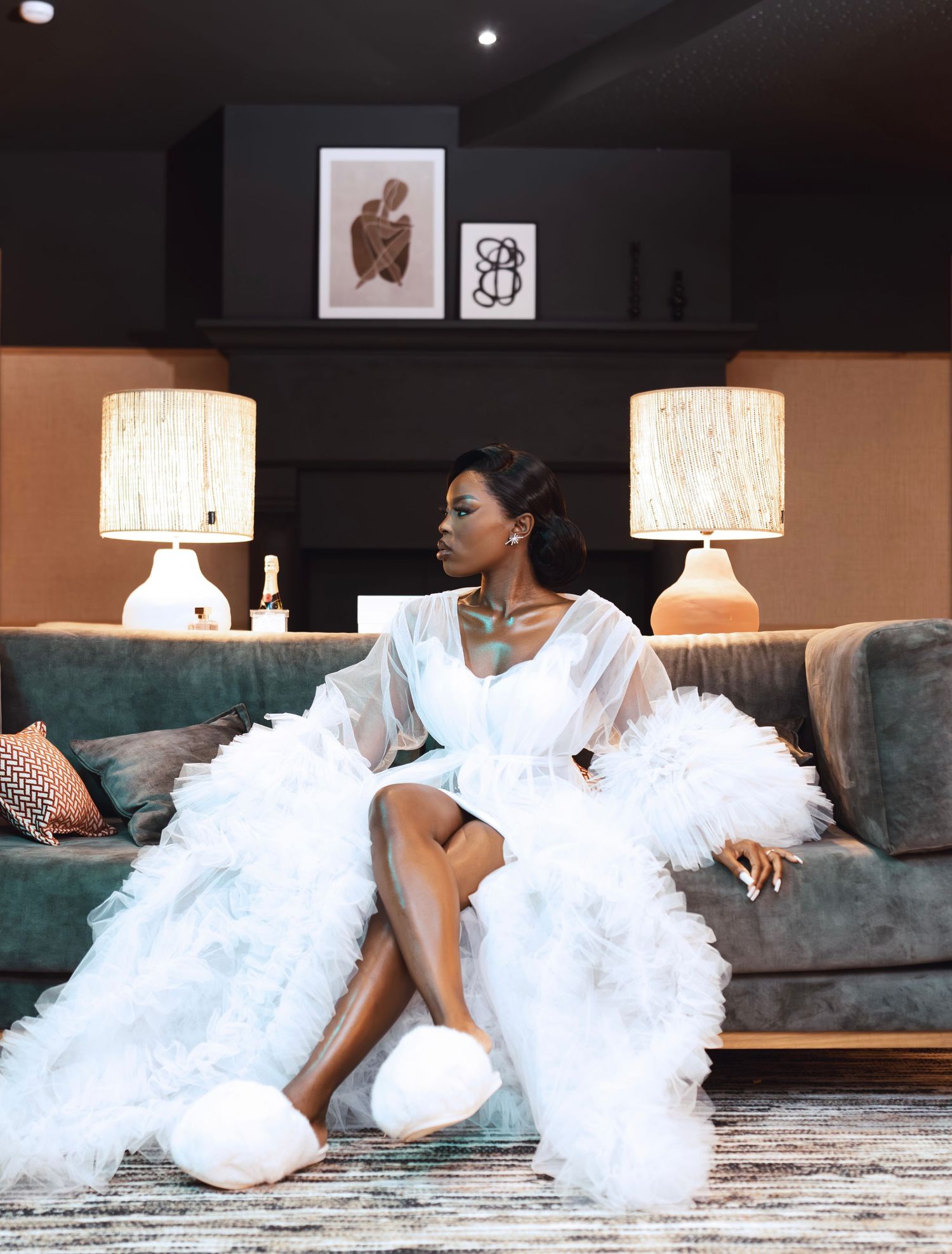 Elegant white dress photography session on a luxurious couch with ambient lighting.