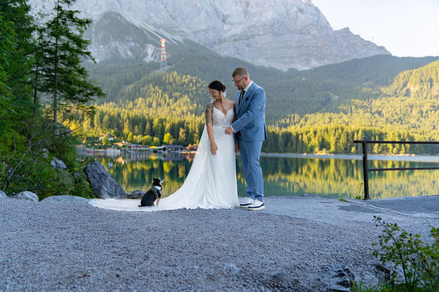 Panoramic view of newlyweds by Minnewanka Lake with Canadian Rocky Mountains in the background.