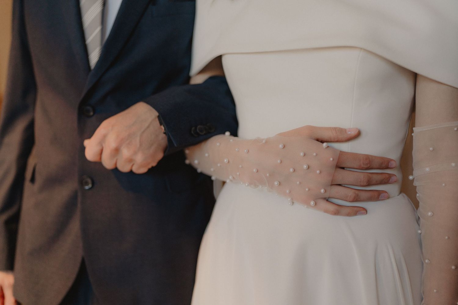 Elegant white wedding dress details with delicate beading.