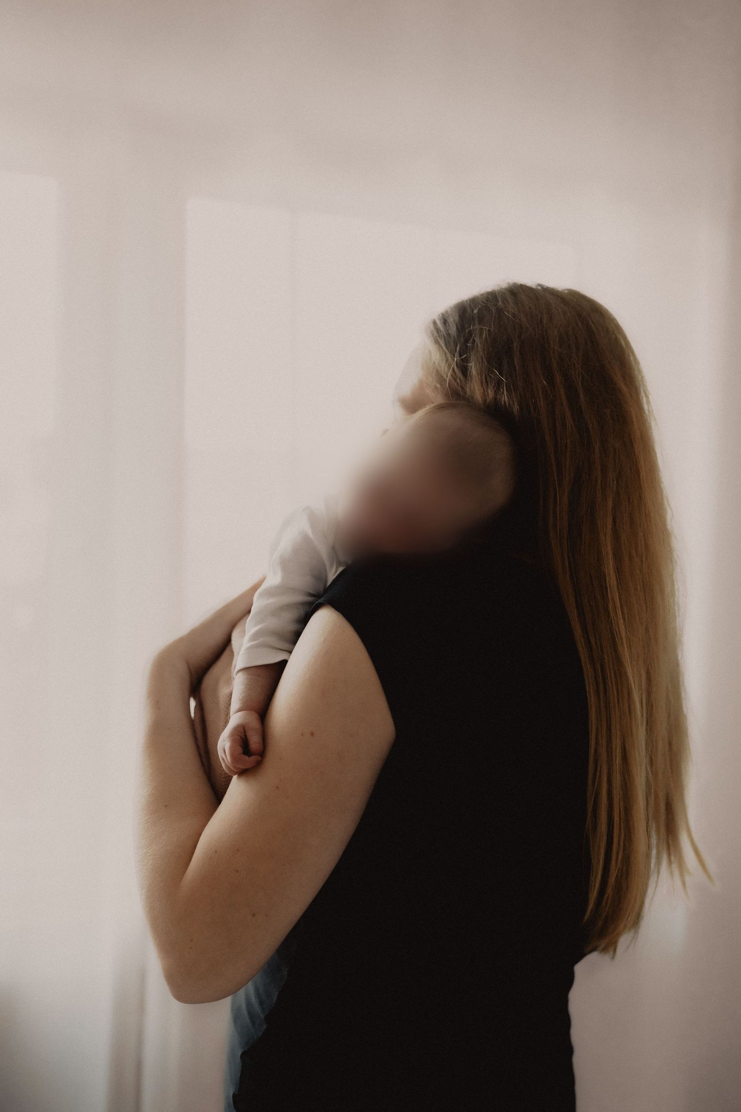 Side profile silhouette of a person with long straight hair wearing a dark sleeveless top against a light background.