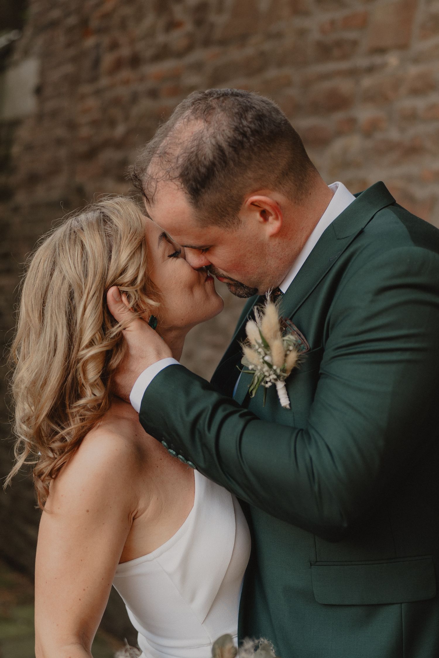 Intimate wedding portraits show couple in emerald suit and white dress sharing romantic moments.