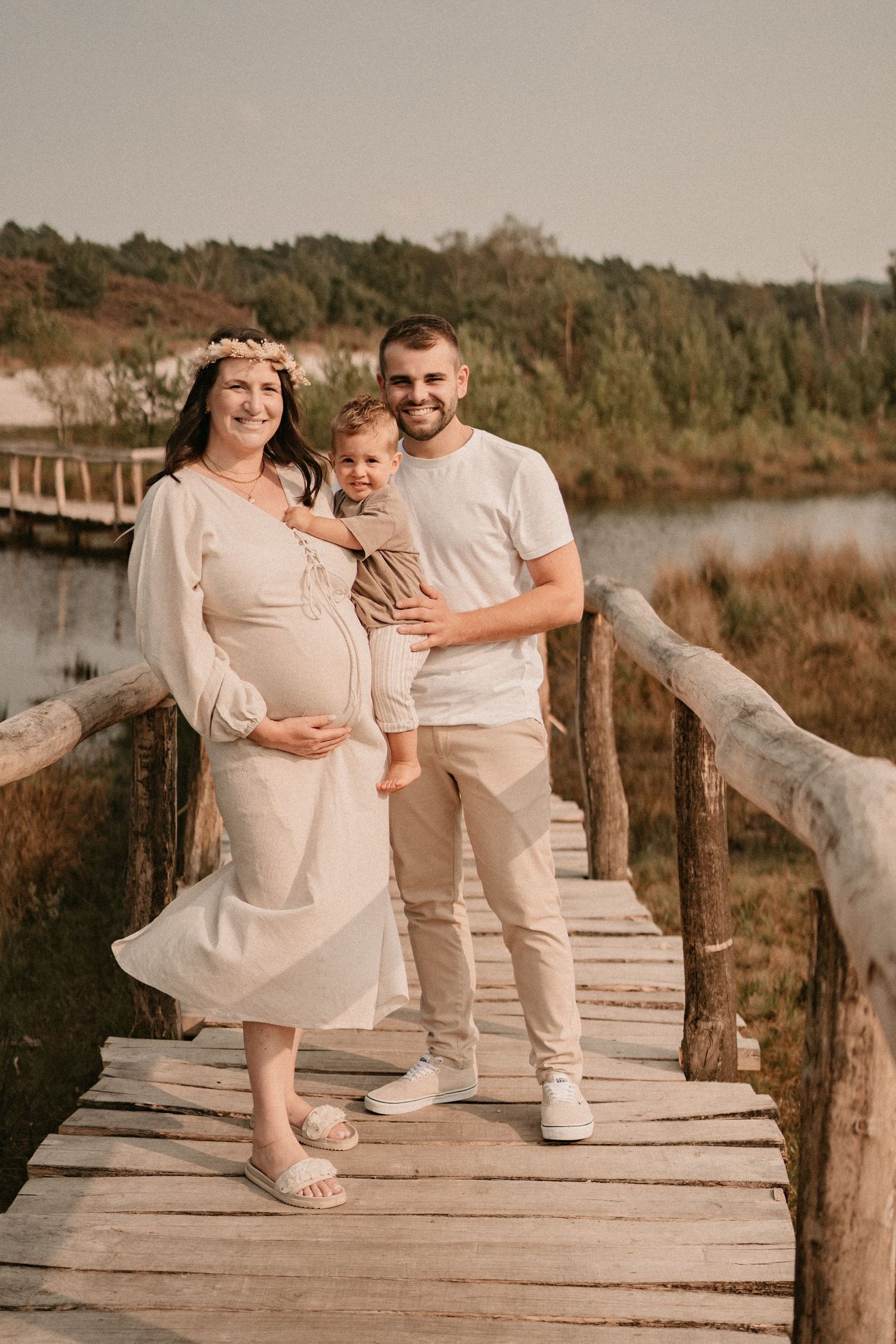 Family enjoying a casual photo session on a rustic boardwalk near the water.