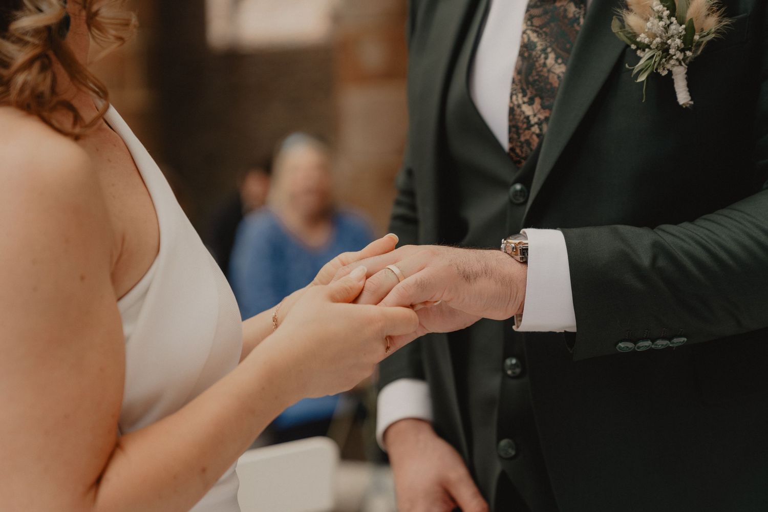 Couple signing marriage documents at a rustic venue with brick walls in the background.