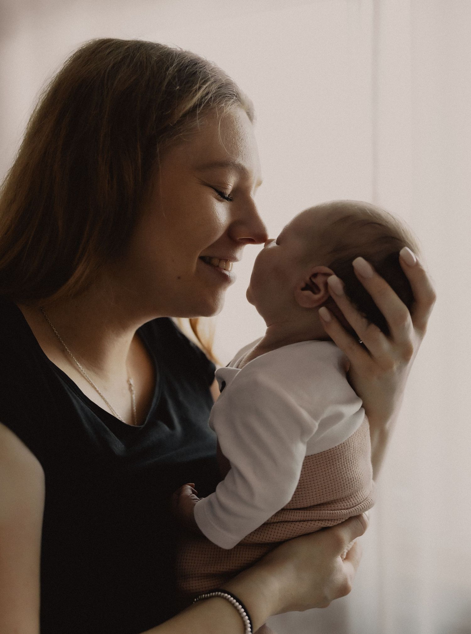 A series of intimate silhouette portraits showing tender moments between parent and baby against a light background.