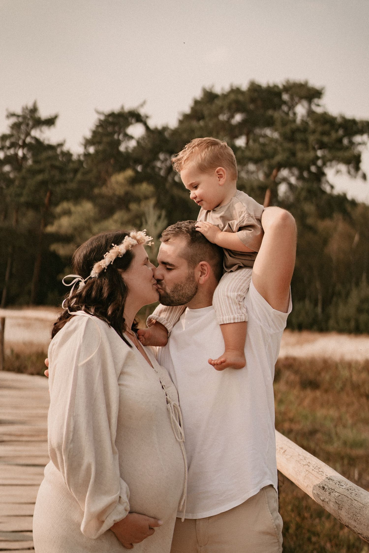 Family sharing tender moments together on a wooden boardwalk near the beach.