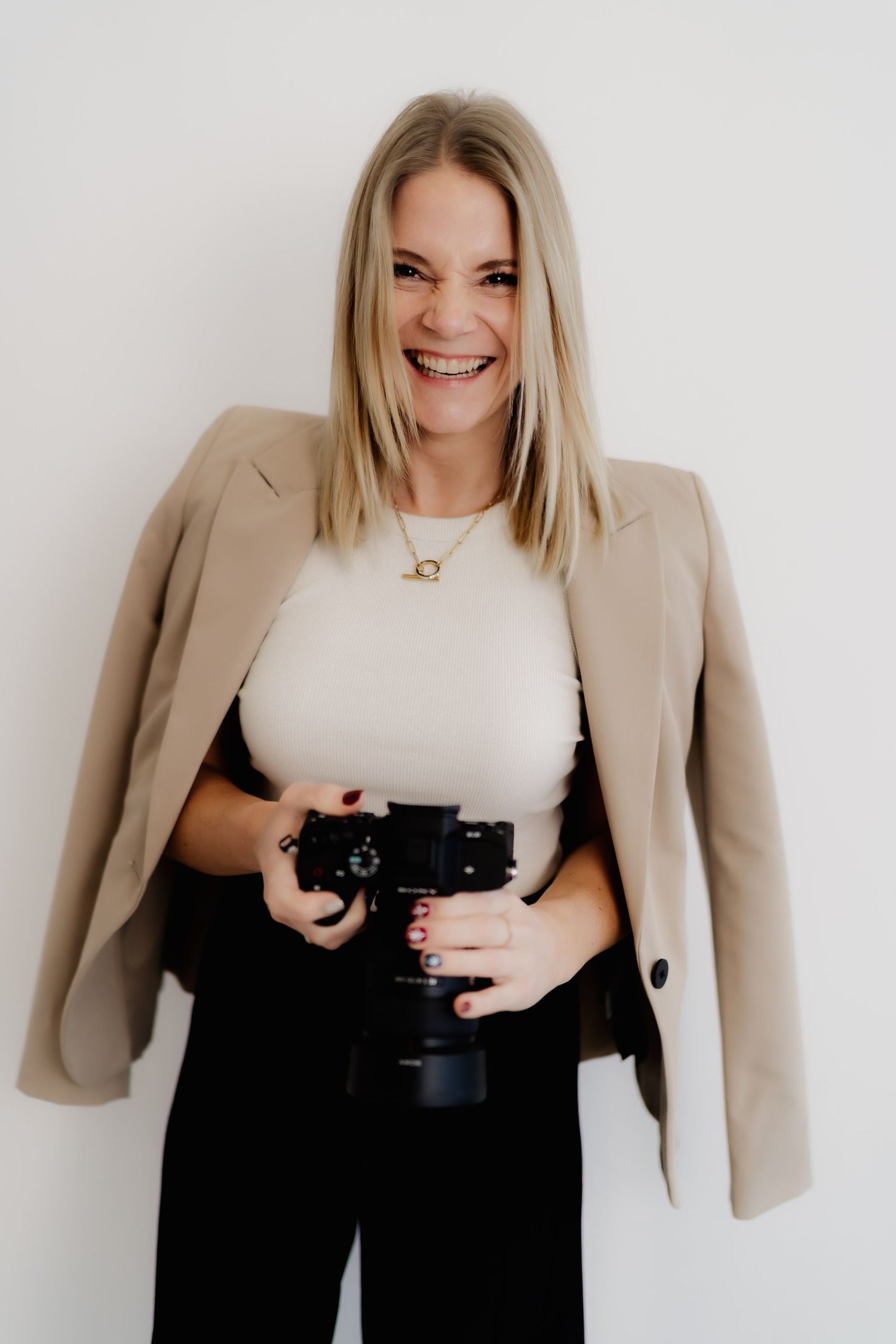 Professional fashion photo series showing person in beige blazer and black pants posing against white background.