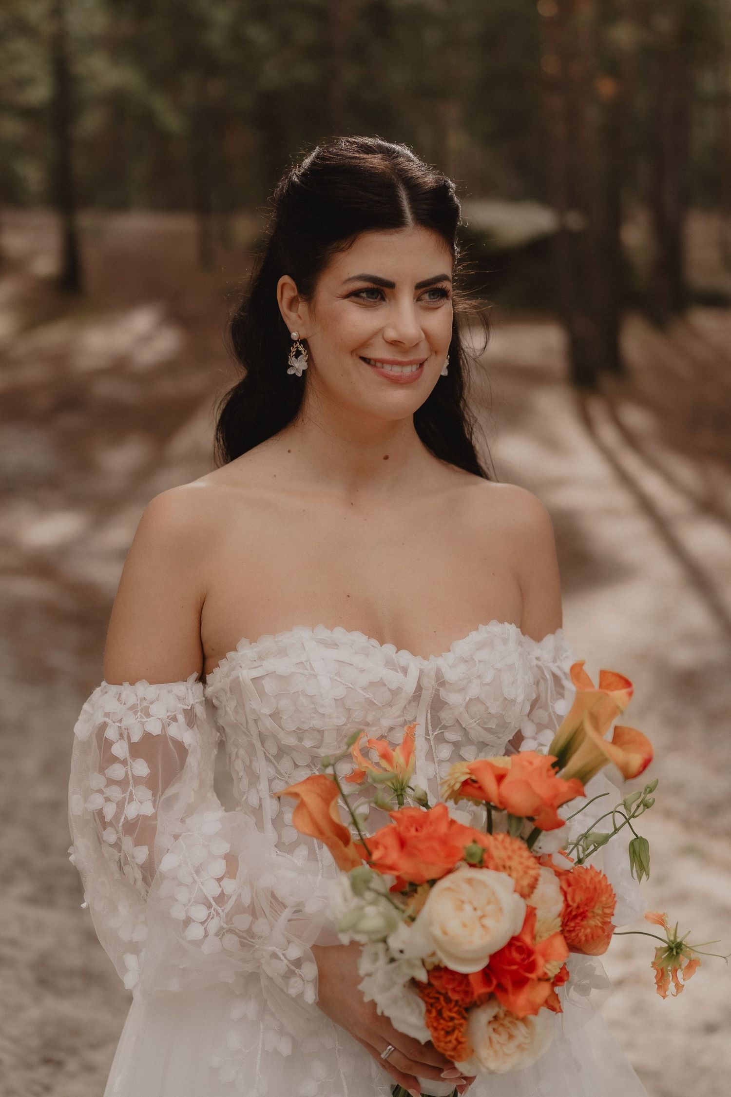 Close-up shots of a bridal bouquet featuring vibrant orange and peach flowers with white accents.