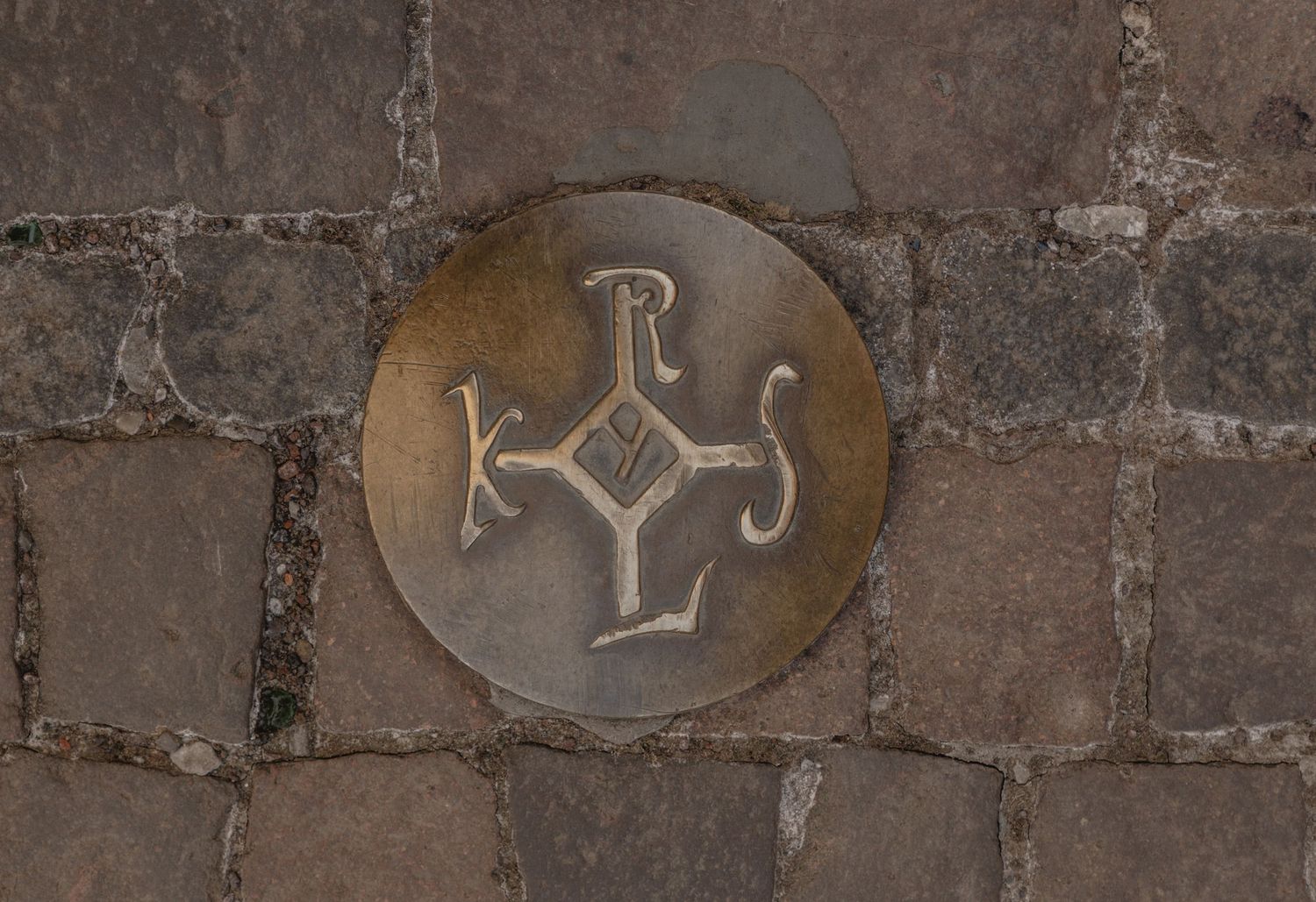 Rustic stone wall with decorative drink symbols etched into surface.