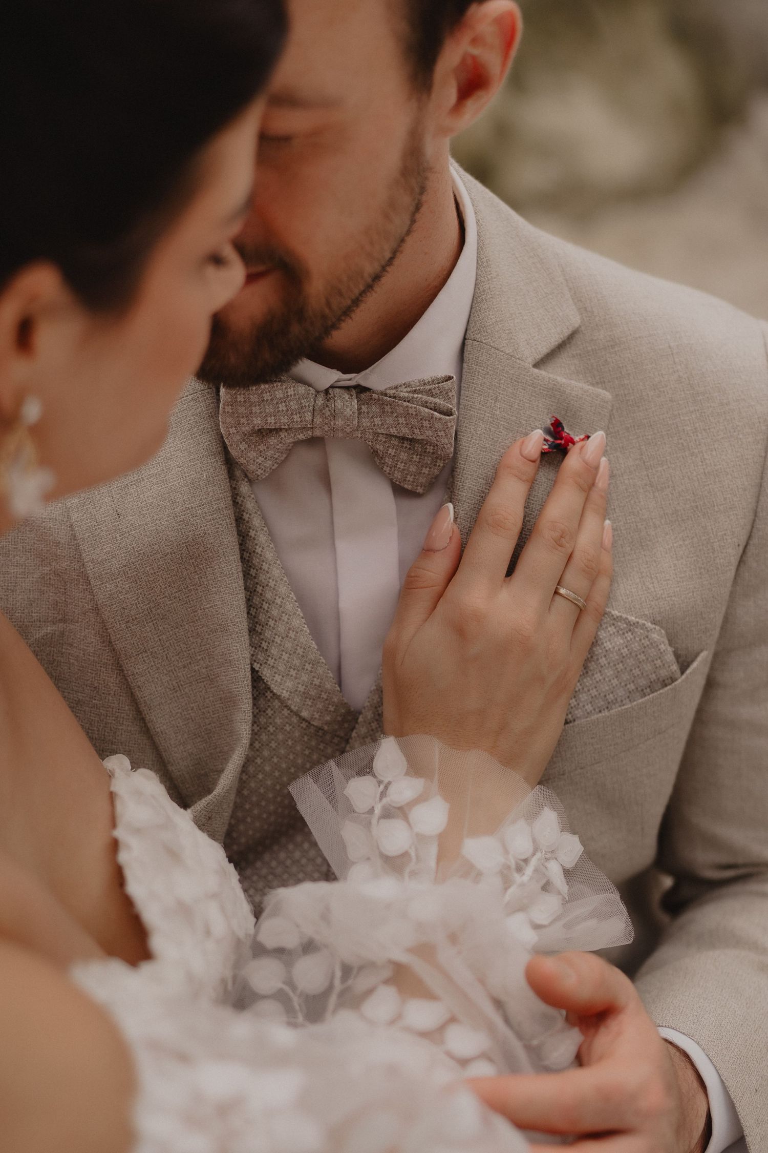 Tender close-up moments between newlyweds wearing beige and white formal attire.