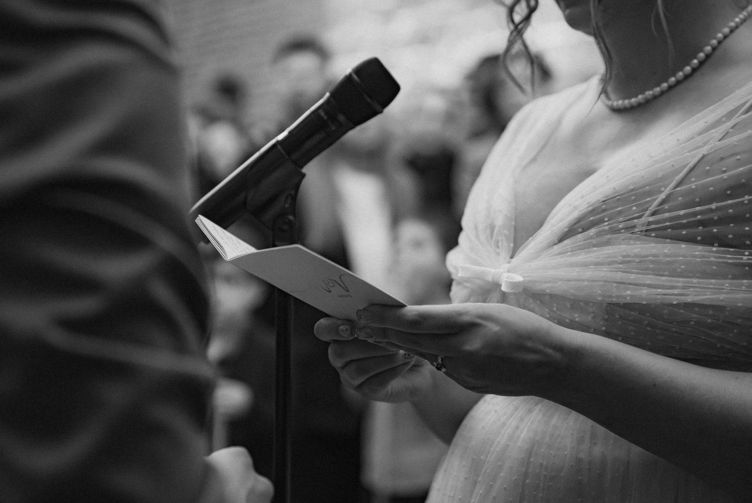 Close-up of hands holding ceremony programs during a wedding service.