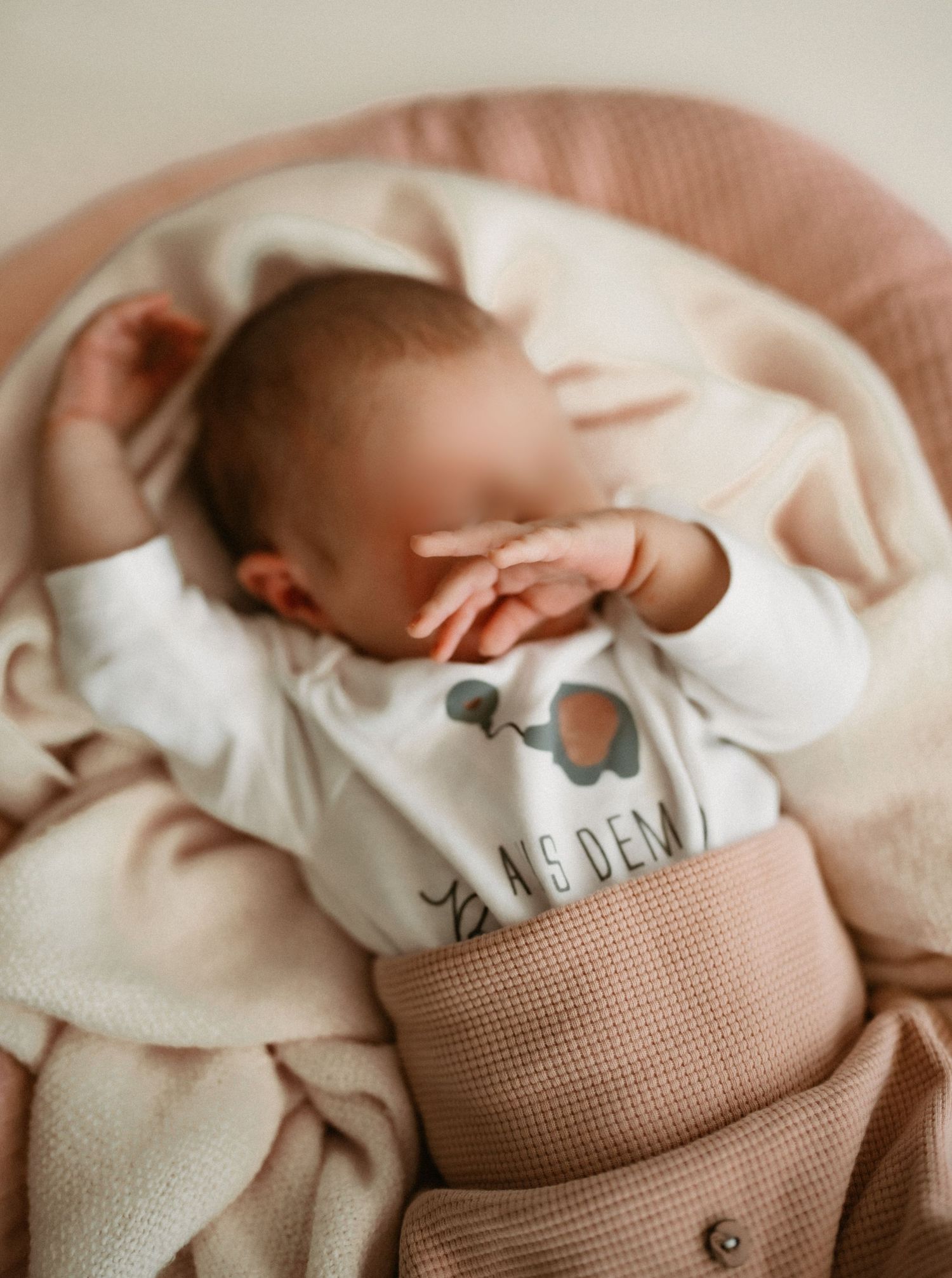 A series of soft, neutral-toned images showing a sleeping newborn baby swaddled in cozy blankets and textured fabrics.
