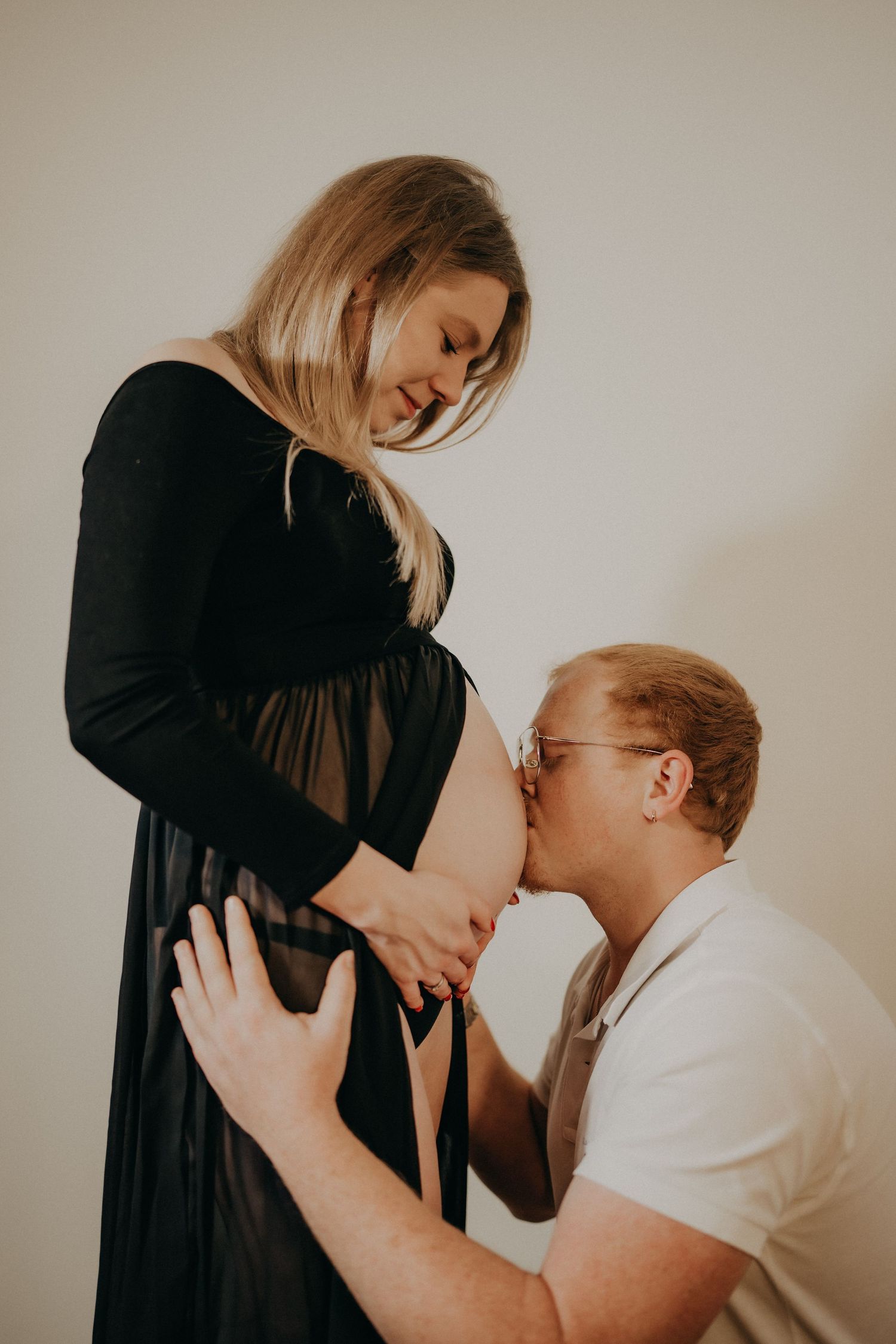 Emotional maternity photoshoot capturing tender moments between couple.