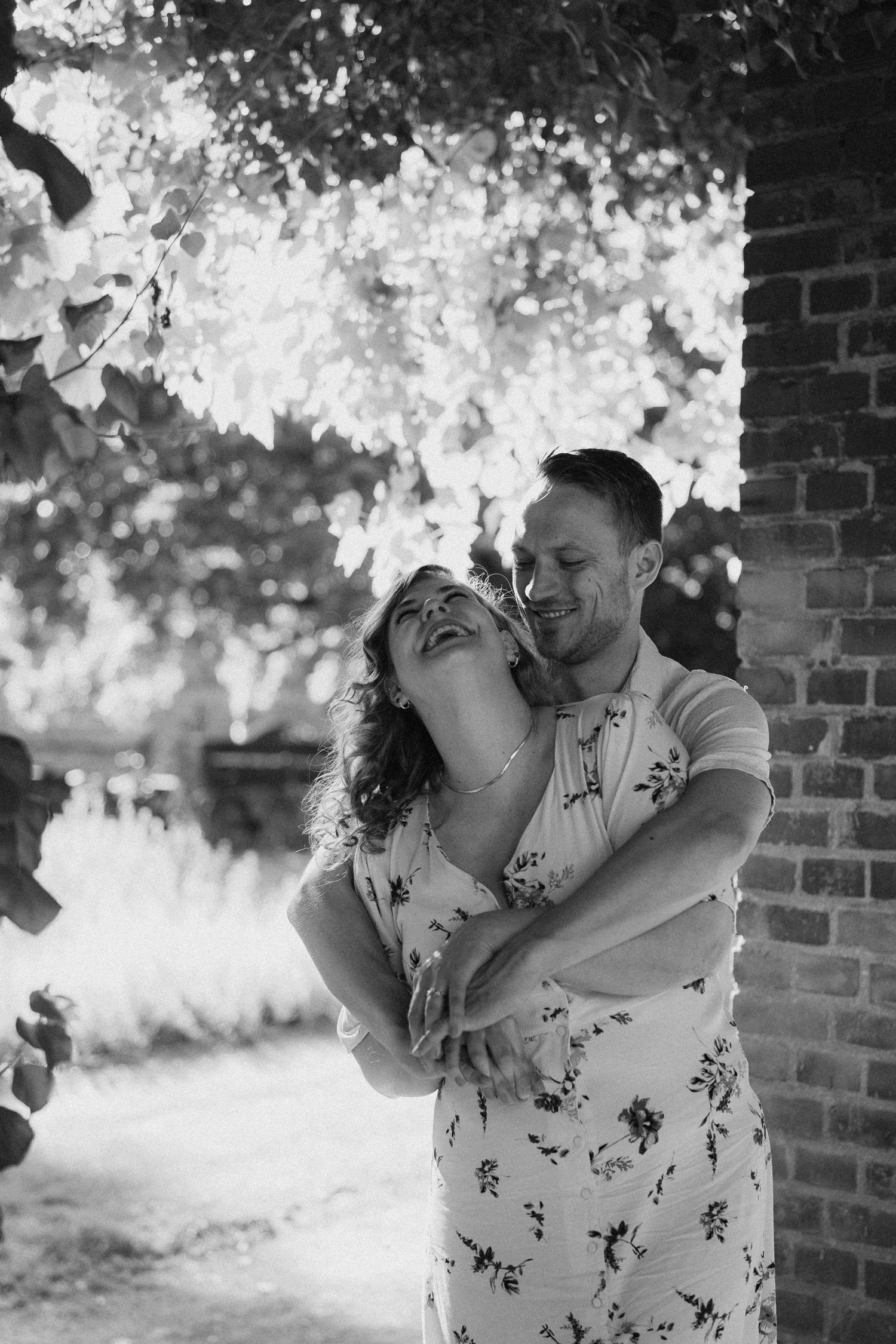 Black and white photos of joyful couple laughing and embracing outdoors.