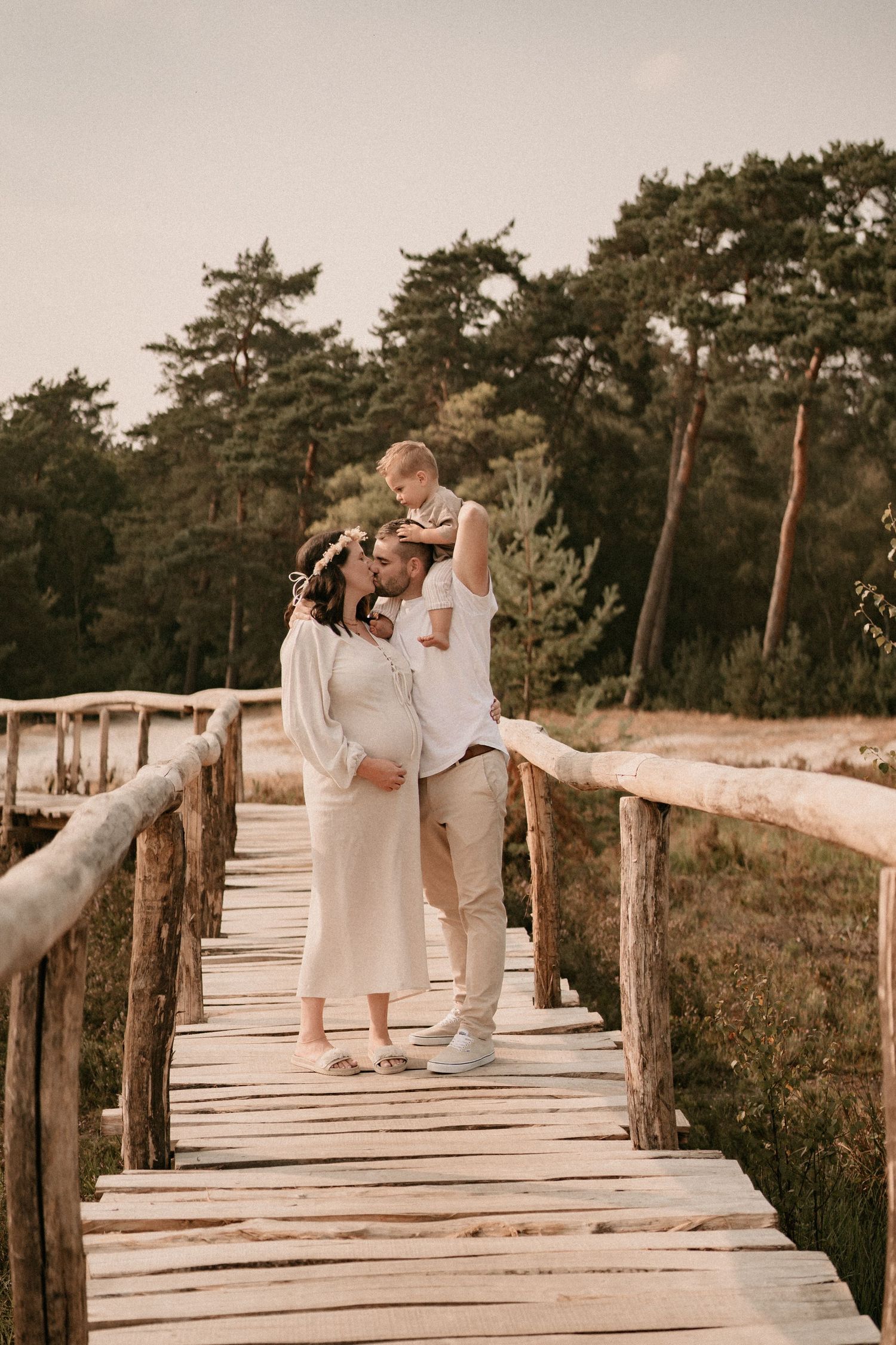 Romantic couple sharing intimate moments on a wooden boardwalk by the beach.