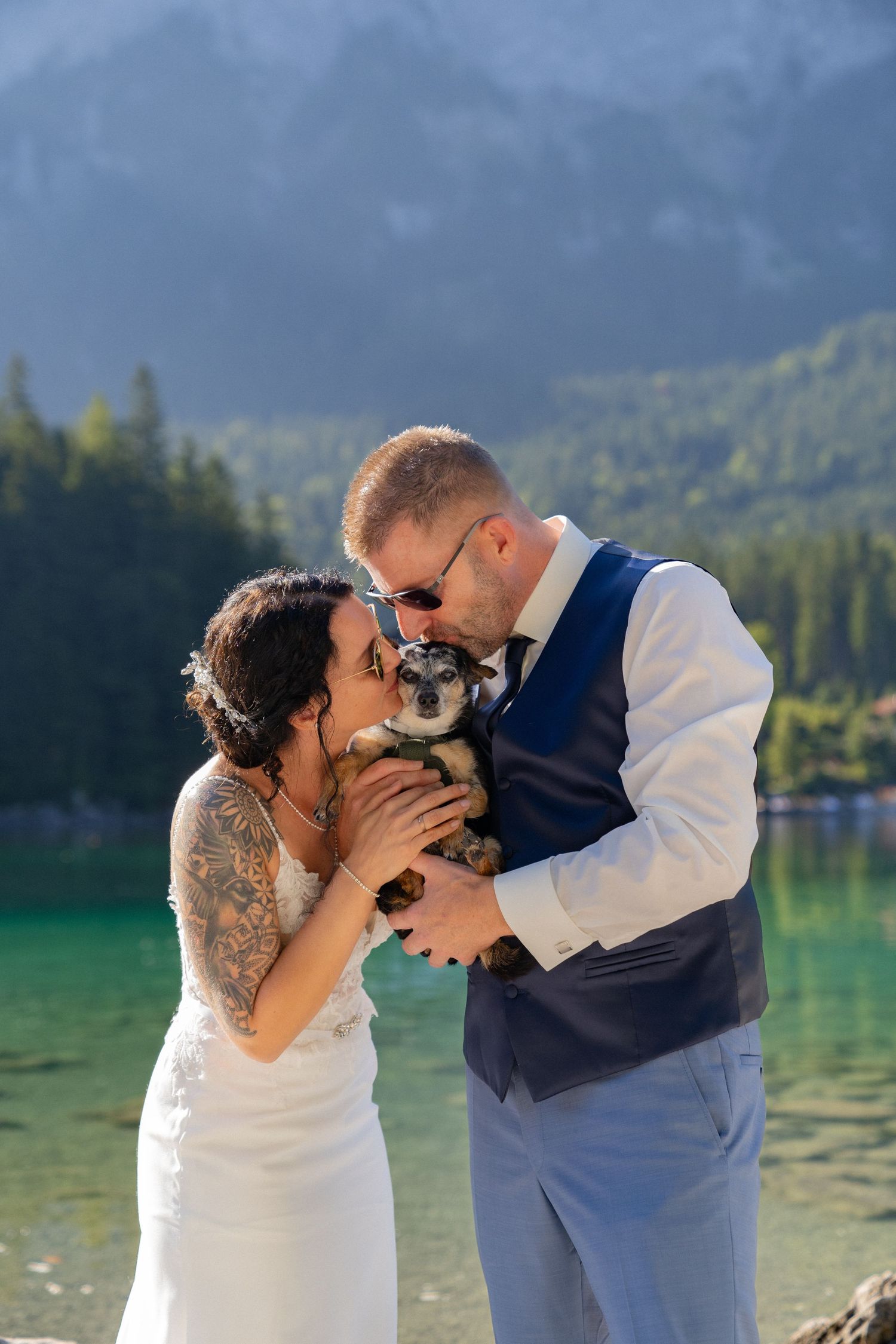 A romantic lakeside moment unfolds against a backdrop of evergreen mountains and crystal clear waters.