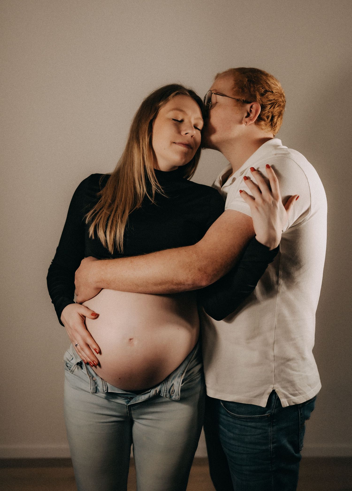 Artistic maternity photography series capturing intimate moments between couple.