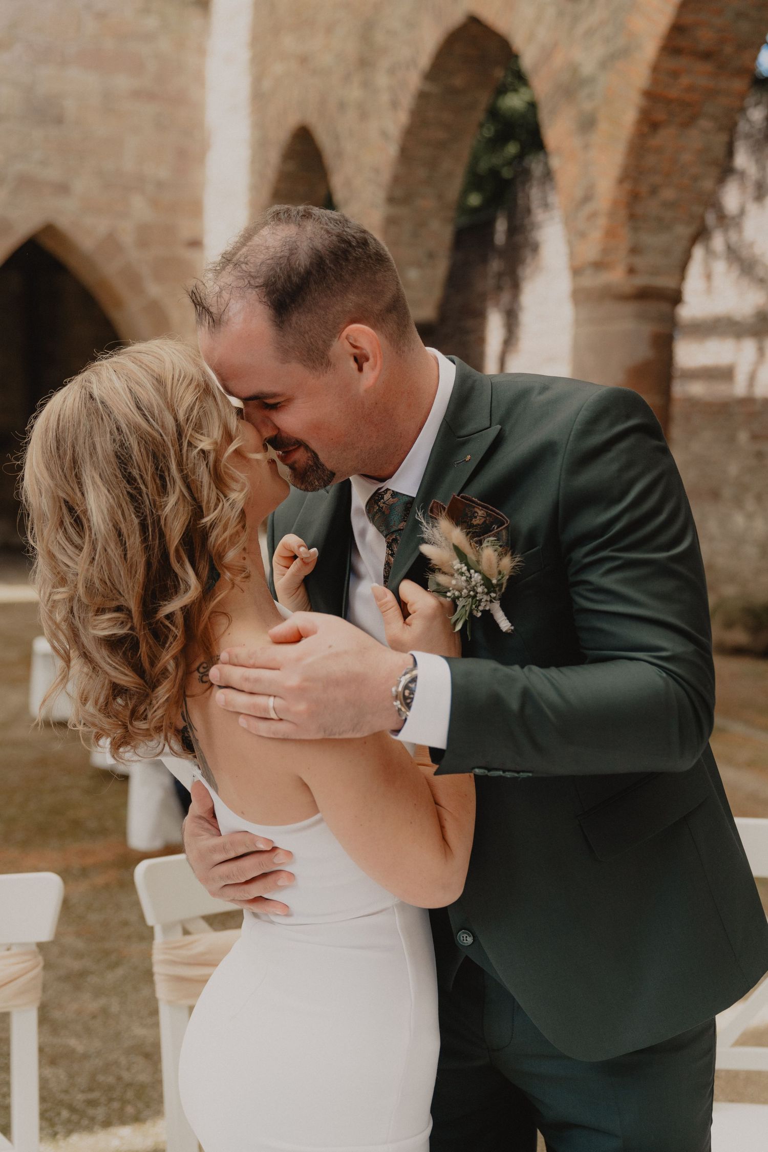 Romantic wedding couple shares intimate moments in a series of tender kisses against rustic brick walls.