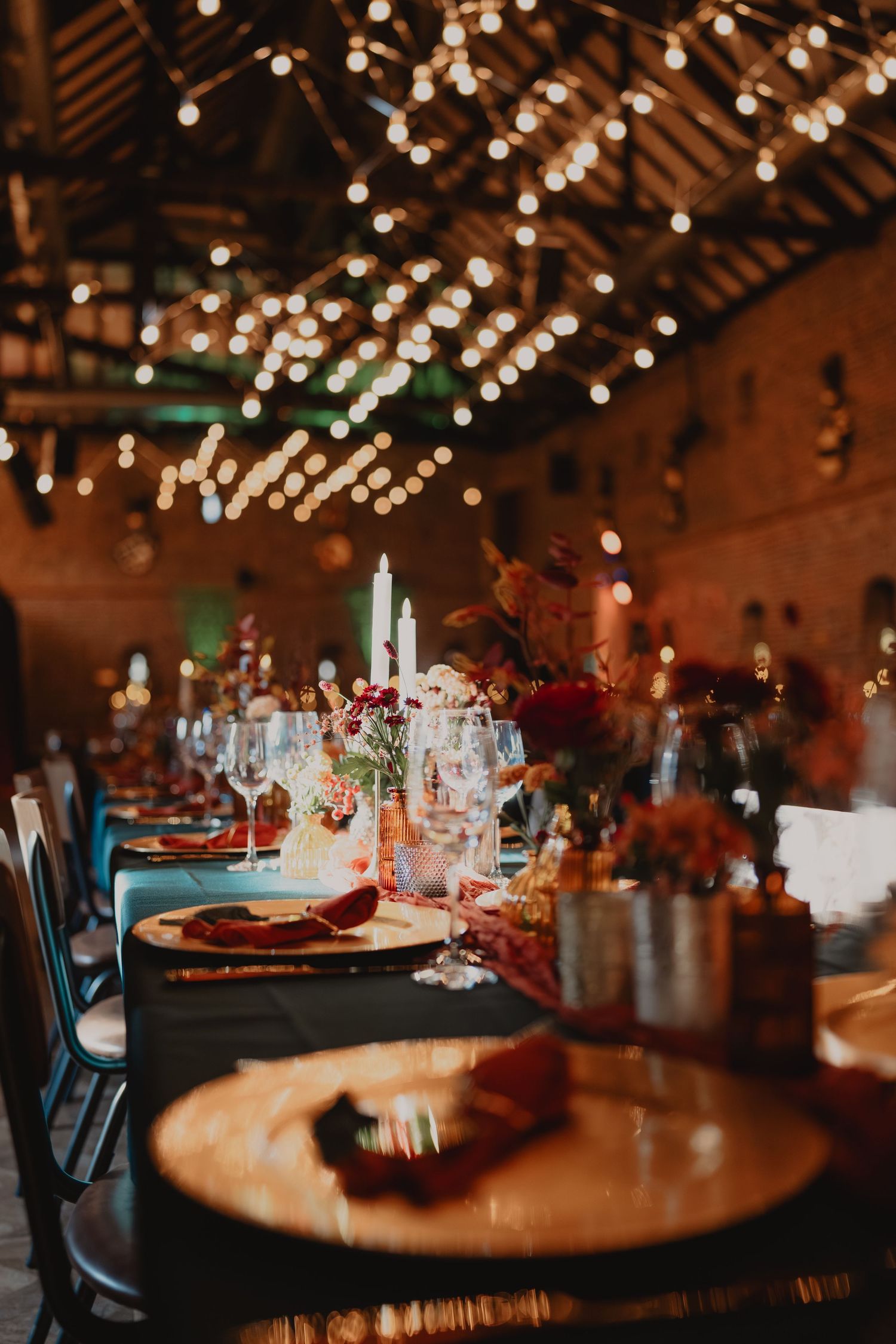 Rustic wedding reception venue with twinkling string lights and wooden tables creating warm ambiance.