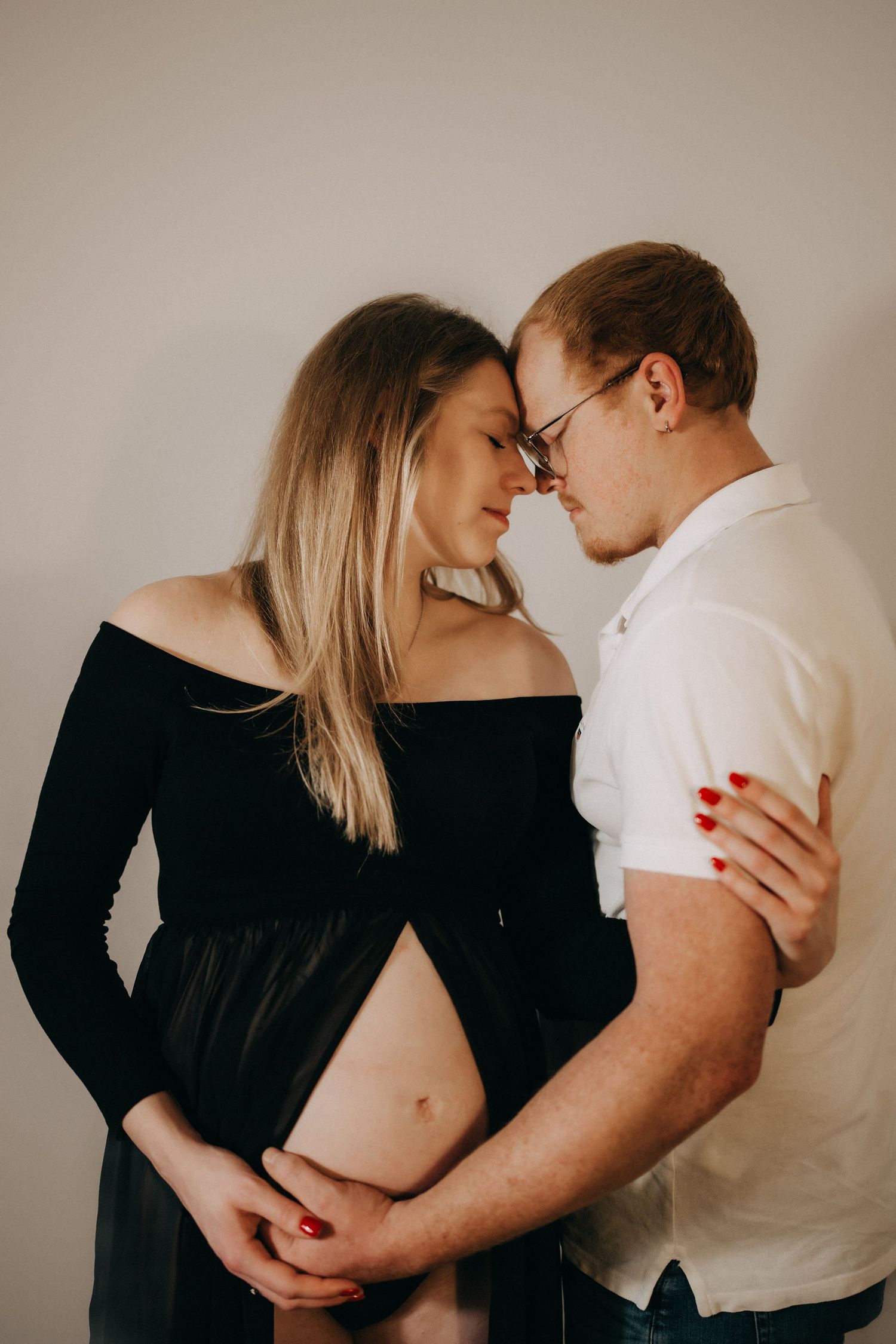 Romantic maternity photos showing tender moments between expectant couple.