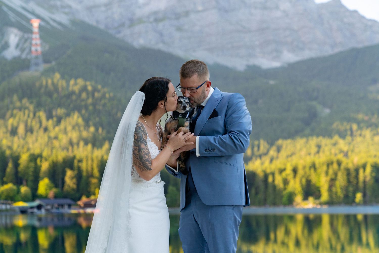 A romantic wedding photo series showing a couple embracing by a scenic mountain lake with fall foliage.