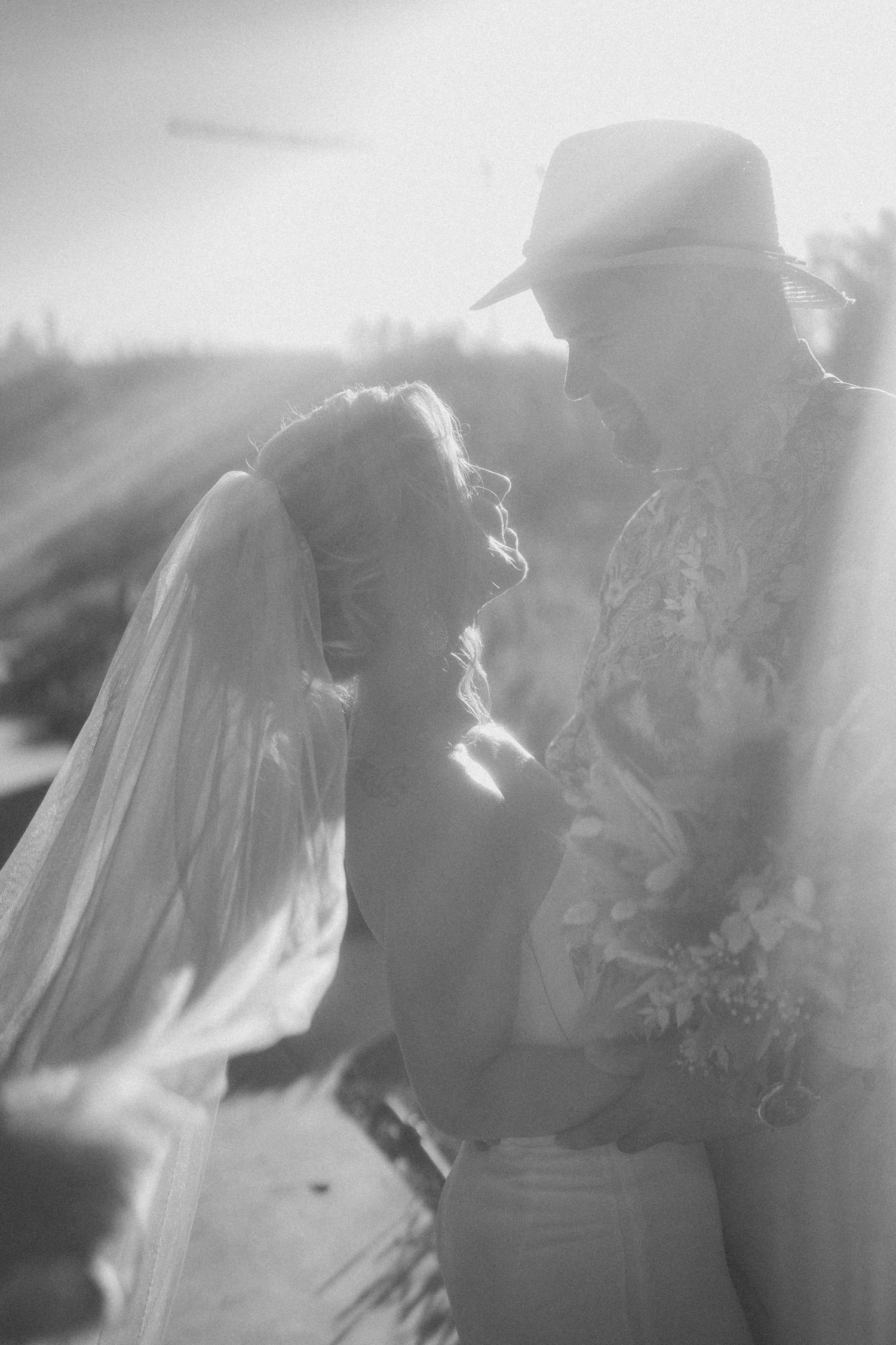 Dreamy black and white photo of a couple sharing an intimate moment on their wedding day.
