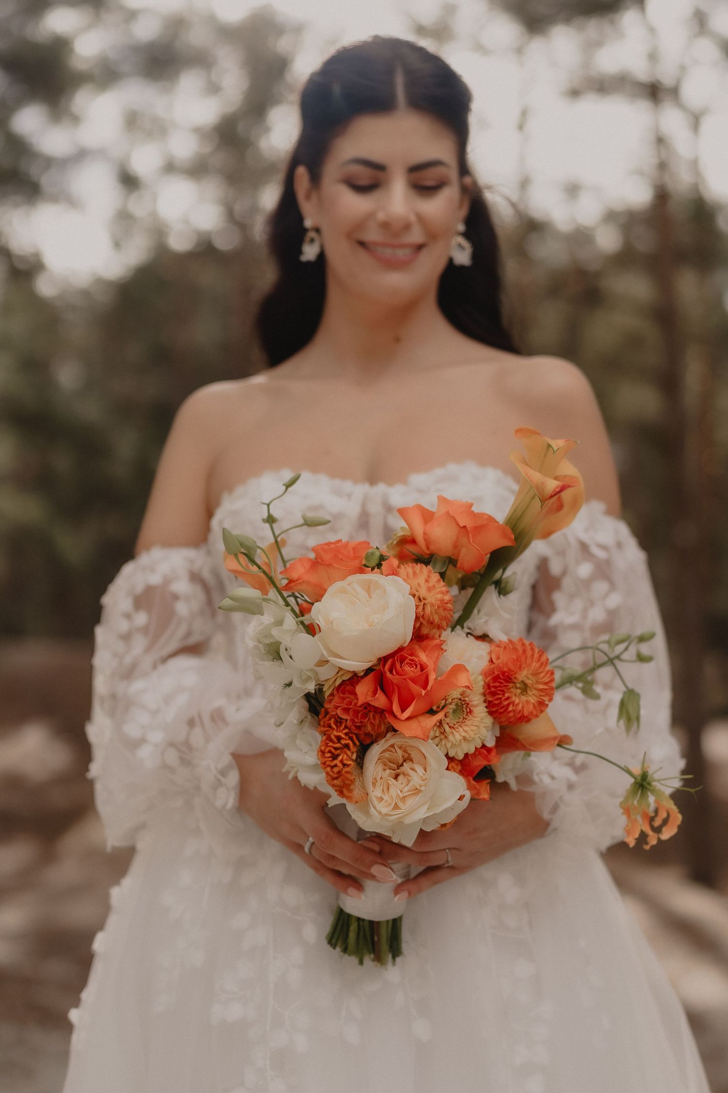Close-up of a peach and cream bridal bouquet with roses and seasonal flowers.