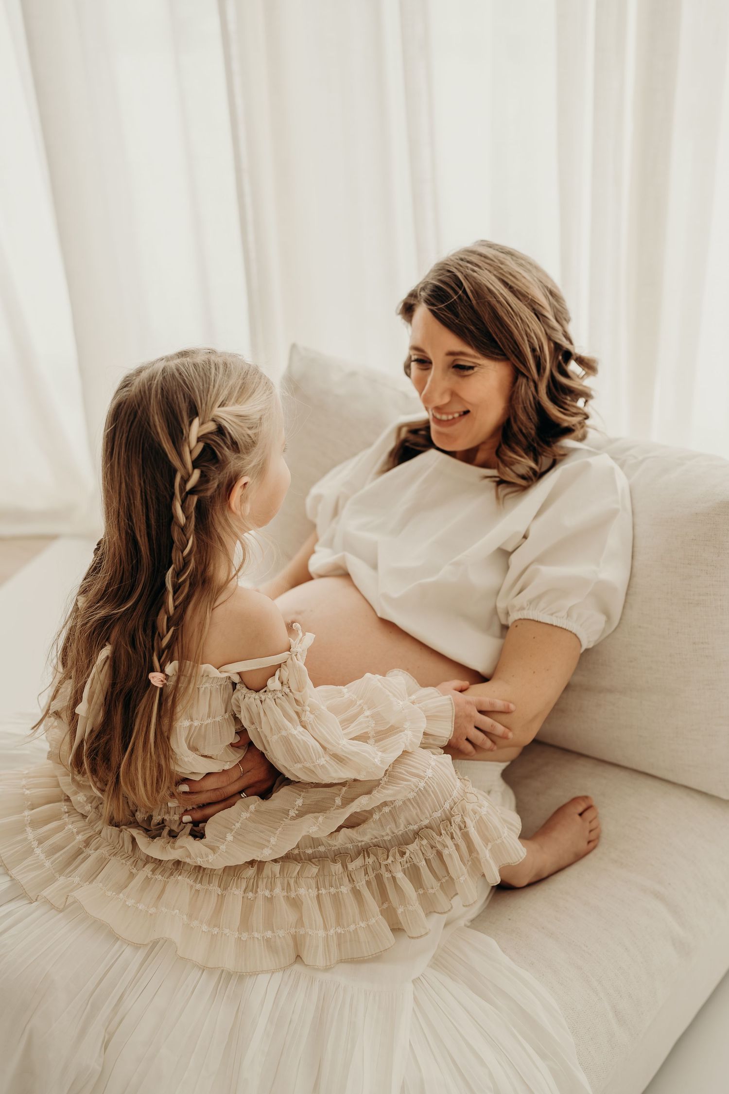 a pregnant mom and daughter on a couch photographed by an east troy wisconsin maternity photographer Blakeslate photography