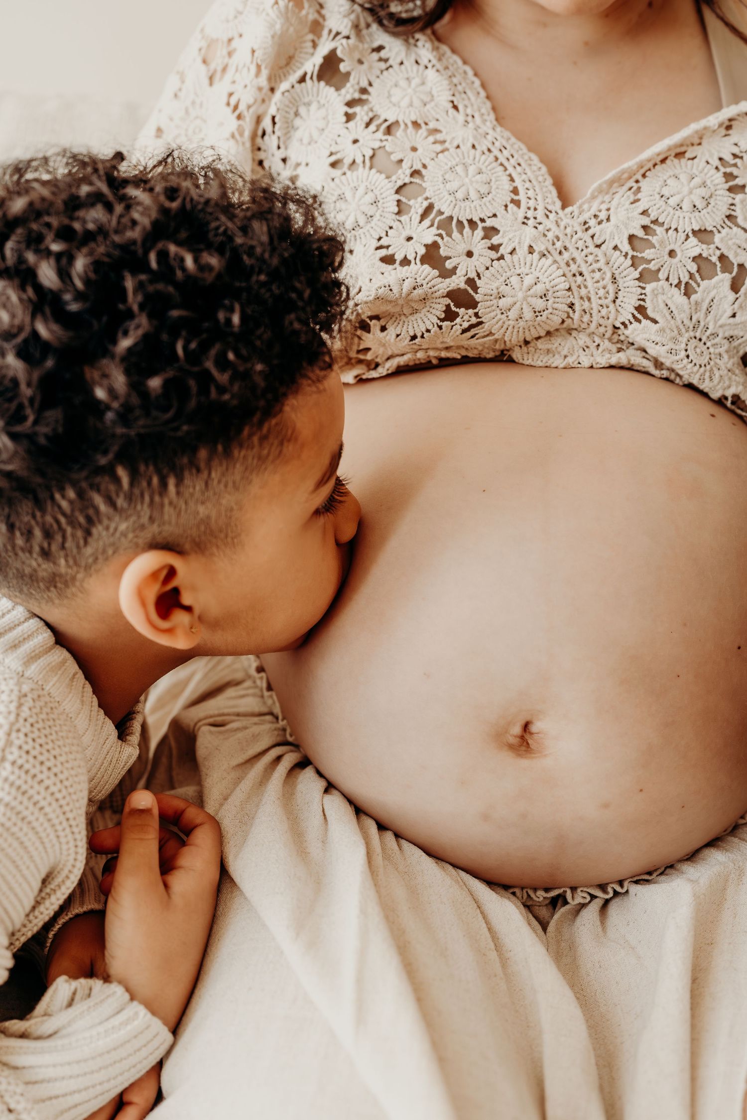 Big Brother kissing mom's belly during a maternity session in East Troy, Wisconsin