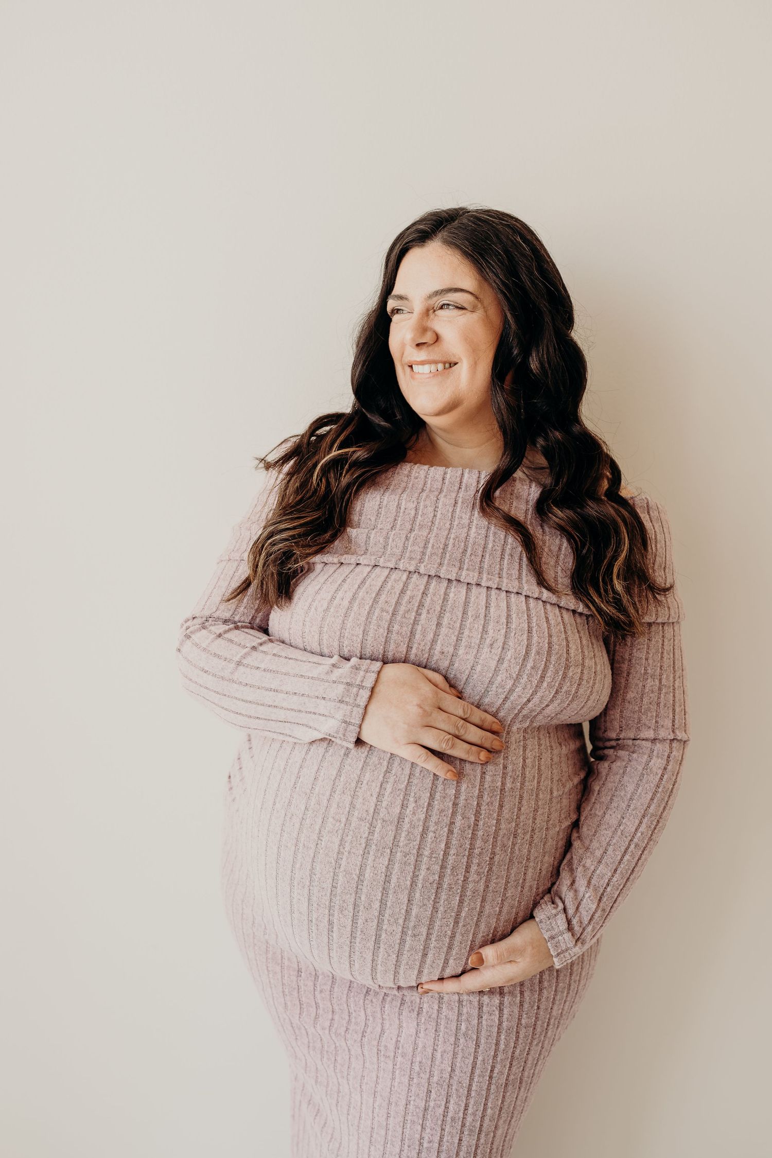 Woman in cozy pink turtleneck sweater poses in four different positions against neutral background makeup done by Cassie
