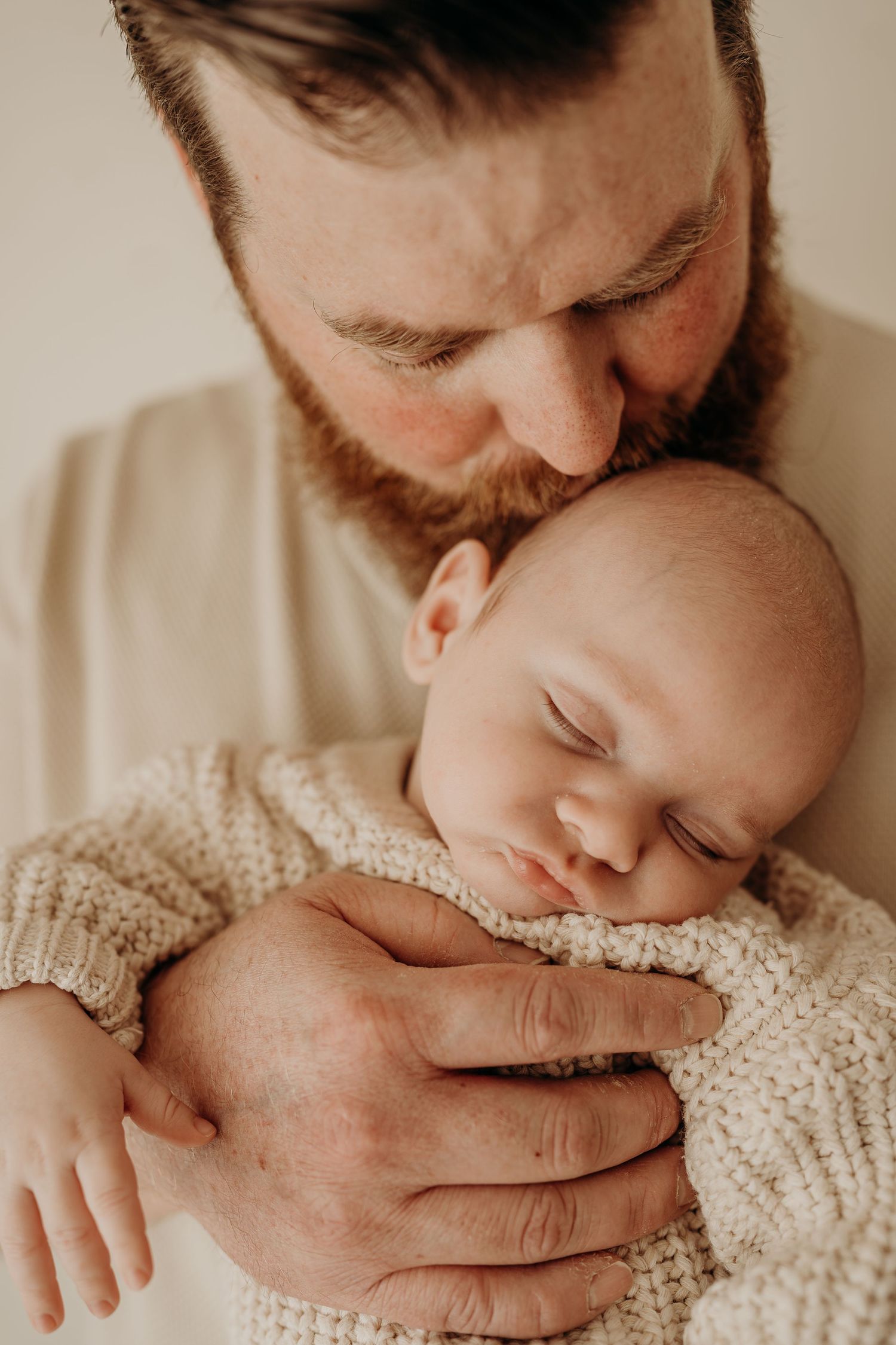 Intimate newborn portrait session with gentle embraces and neutral tones.