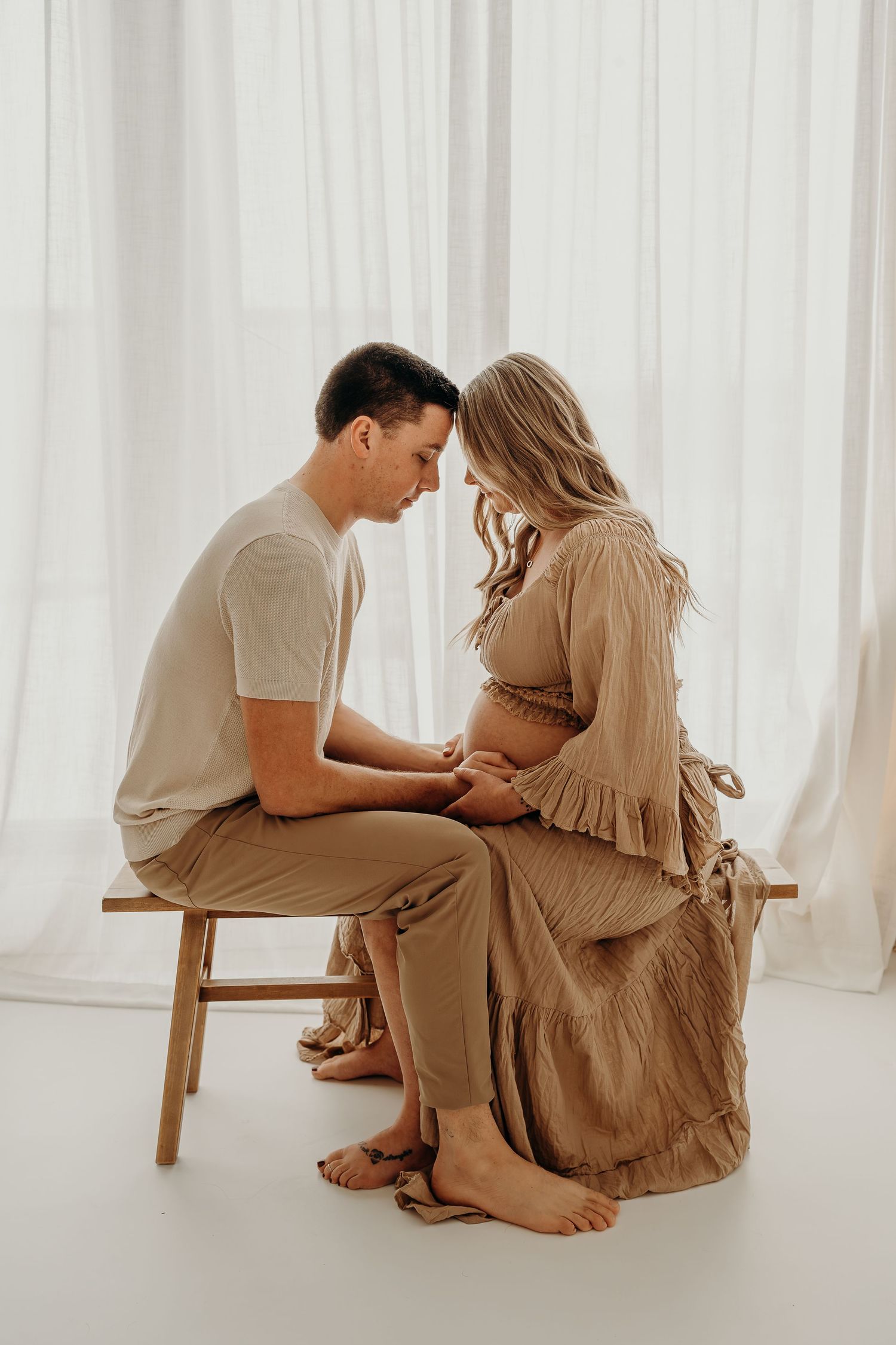 Maternity photographer in East Troy, Wisconsin documenting a tender forehead kiss between mom and dad at SlateStudio.