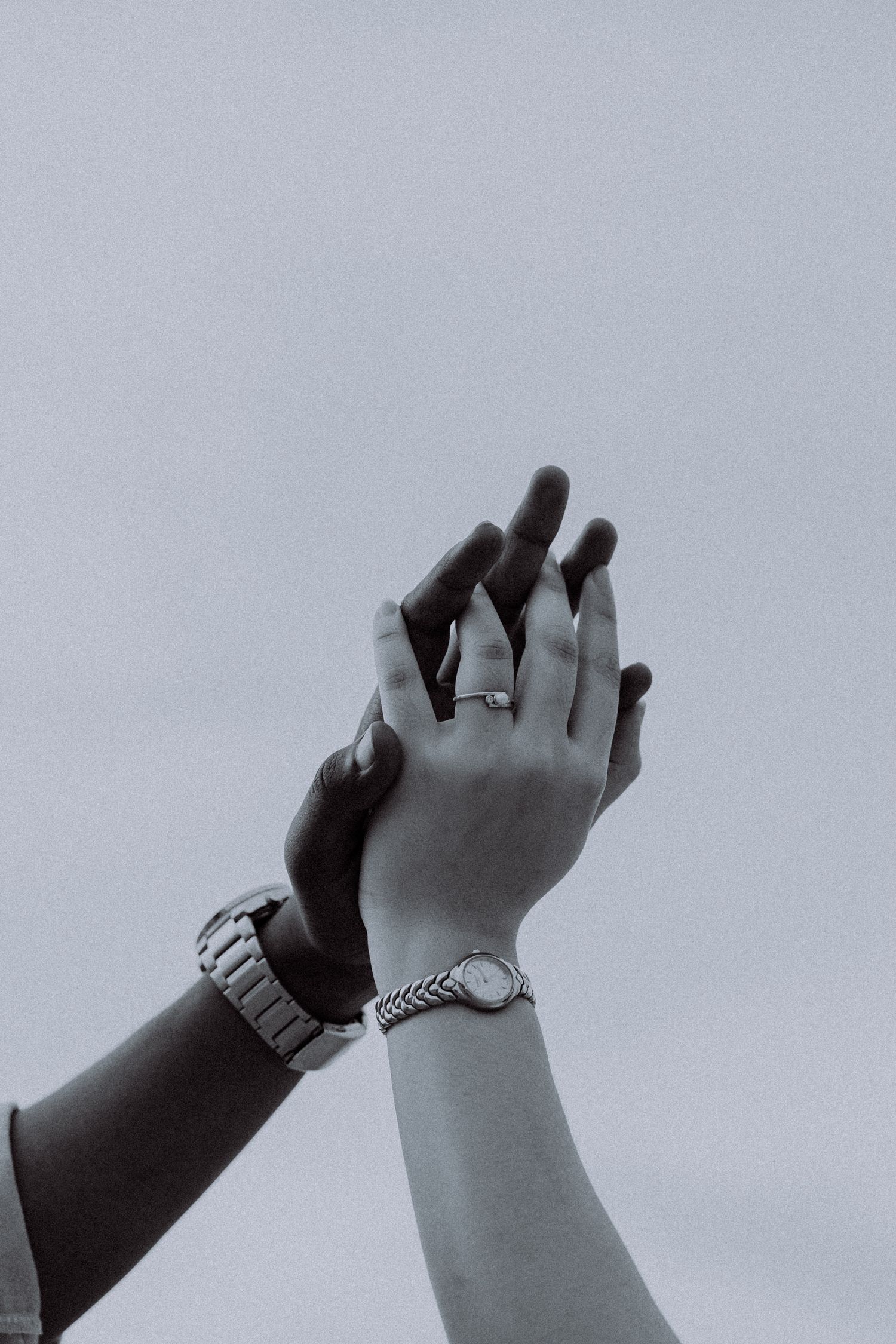 Artistic black and white close-up of a couple holding hands, symbolising love, commitment, and togetherness.