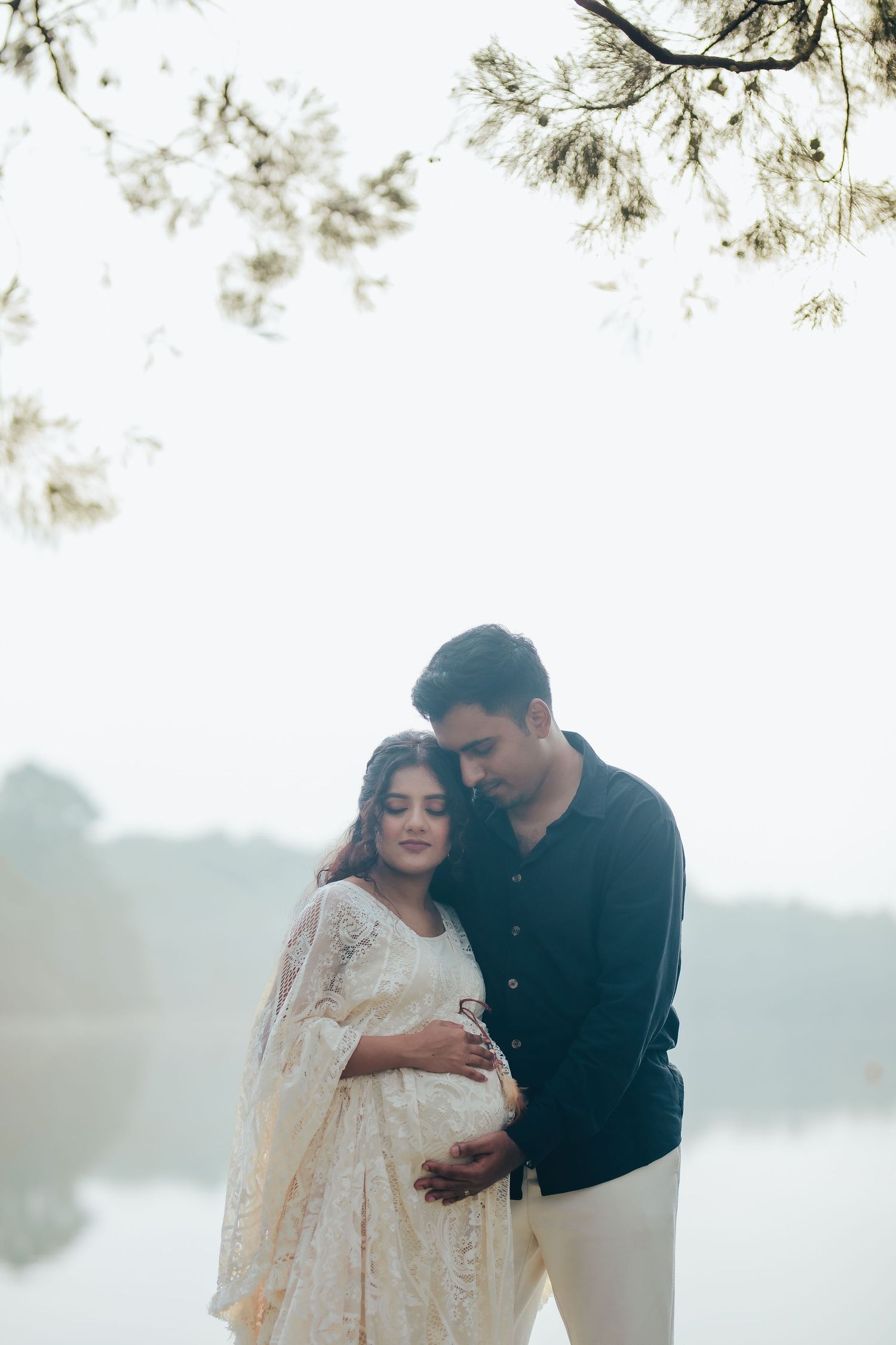 Couple embracing outdoors in soft natural light, romantic maternity Singapore