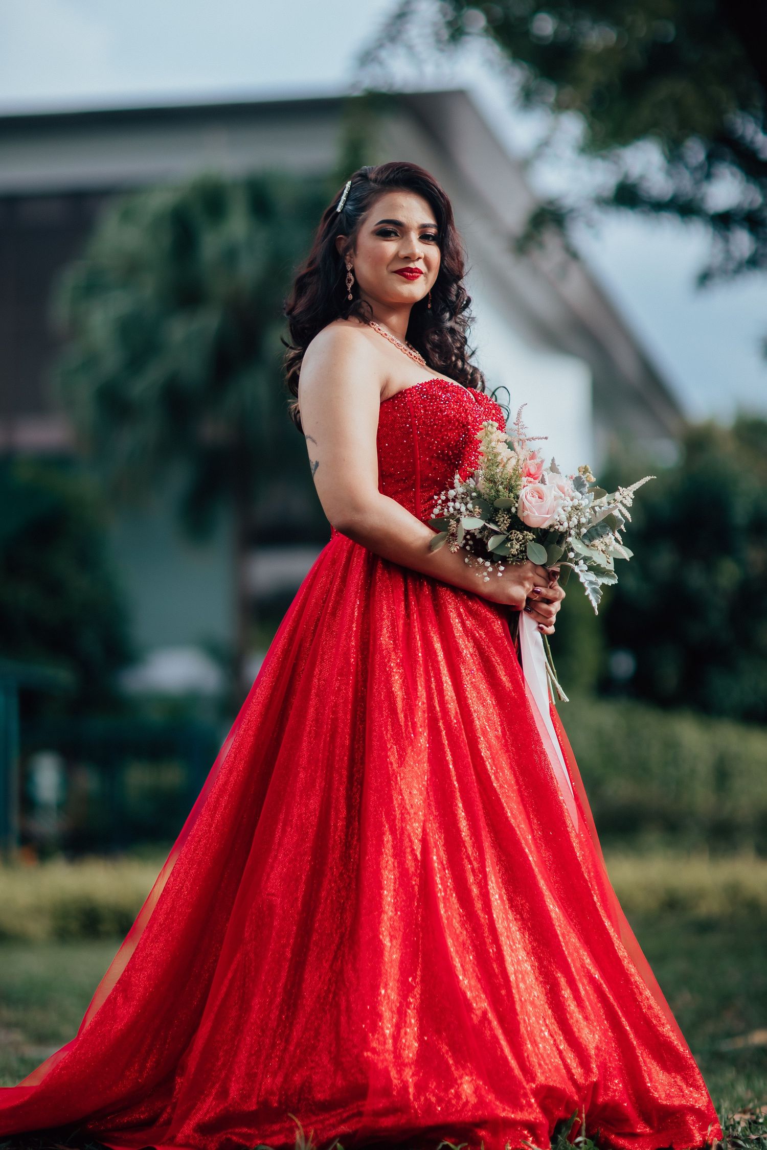 Bride portrait in red gown outdoors, elegant wedding photography